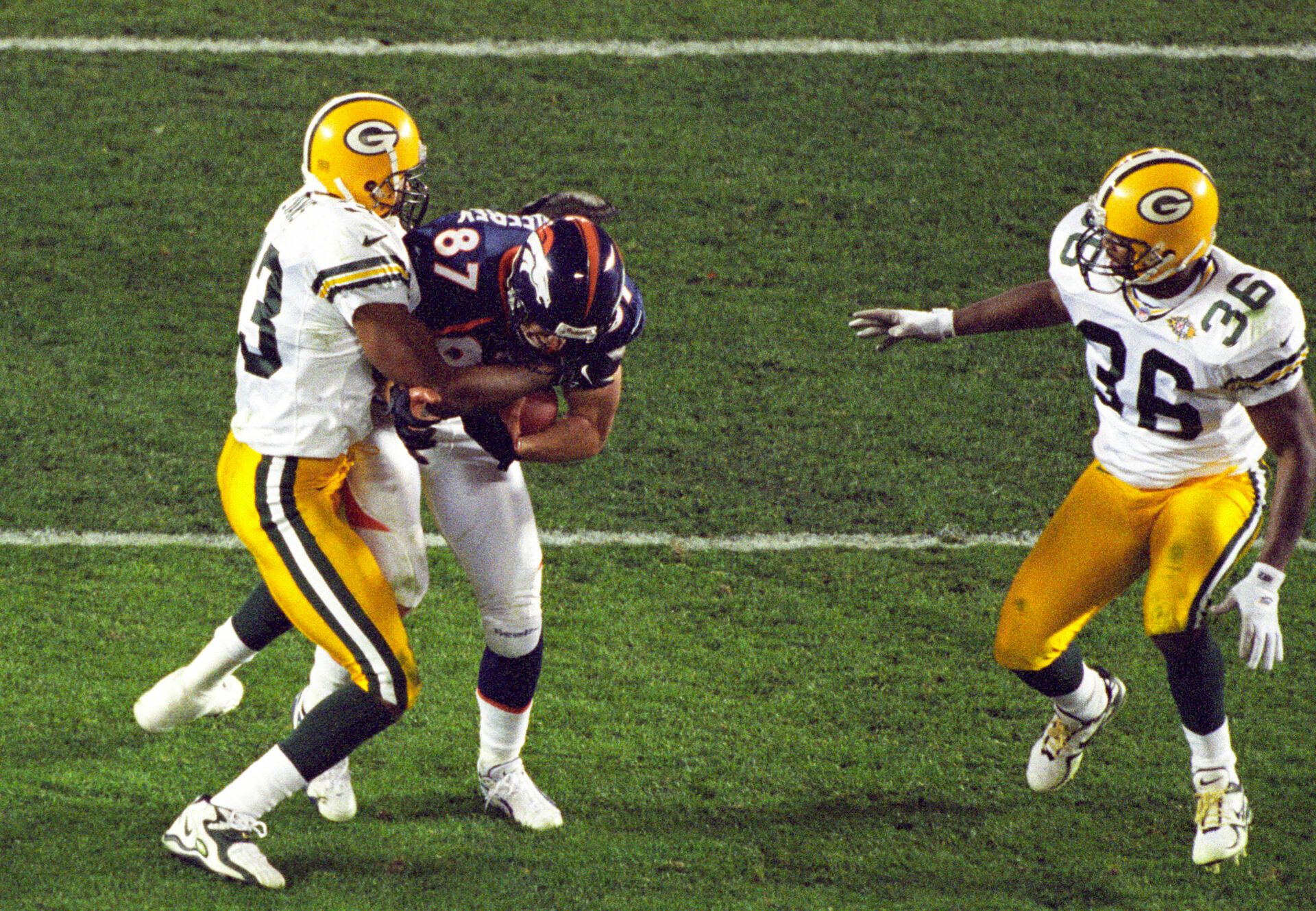 Denver Broncos receiver Ed McCaffrey (87) runs with the ball against Green Bay Packers defensive backs Doug Evans (33) and LeRoy Butler (36) during Super Bowl XXXII at Qualcomm Stadium. The Broncos defeated the Packers 31-24.