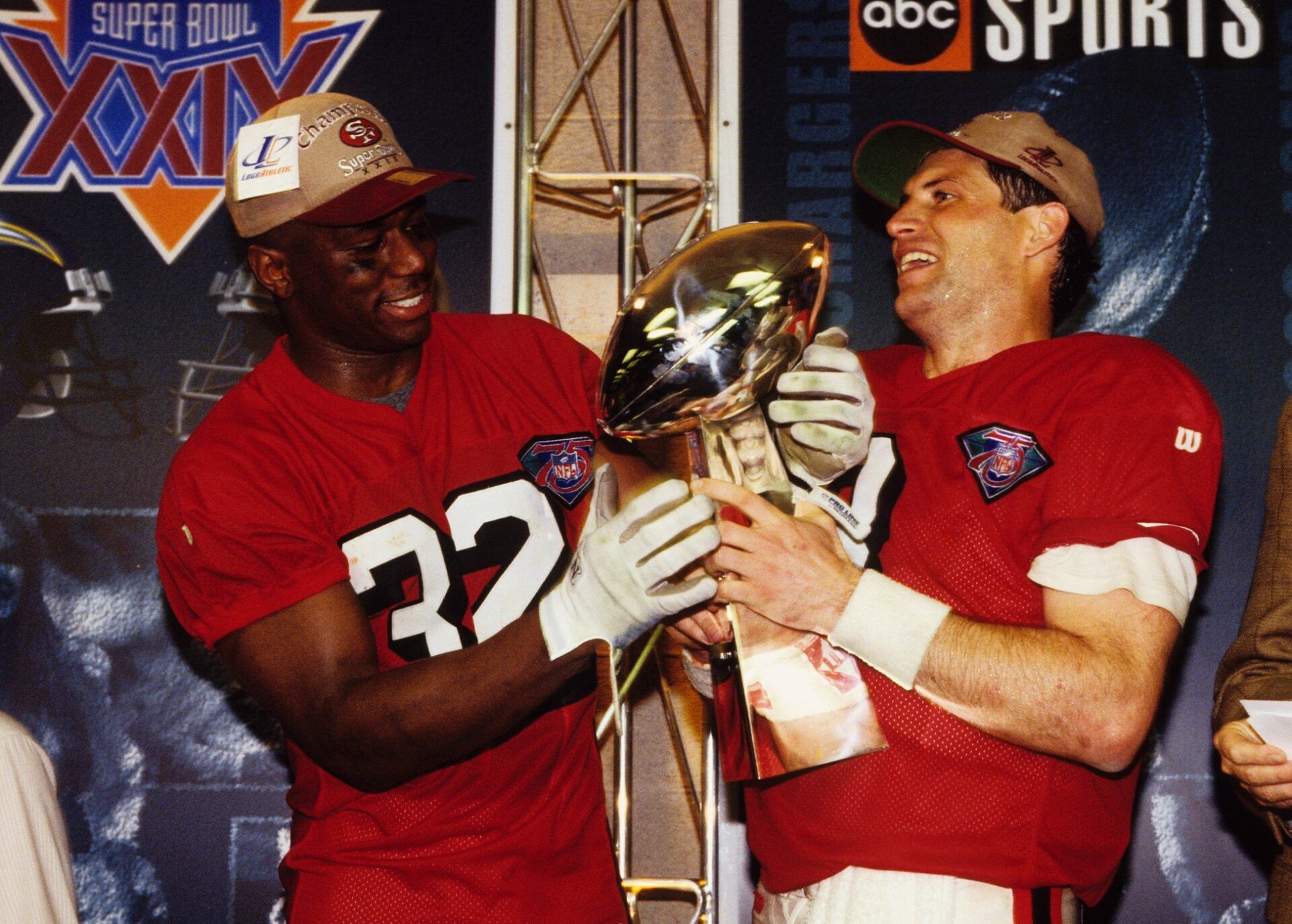 San Francisco 49ers QB Steve Young and RB Ricky Waters holding the Super Bowl trophy.