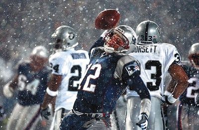 New England Patriots QB Tom Brady (12) spikes the ball during the Snow Bowl against the Oakland Raiders.