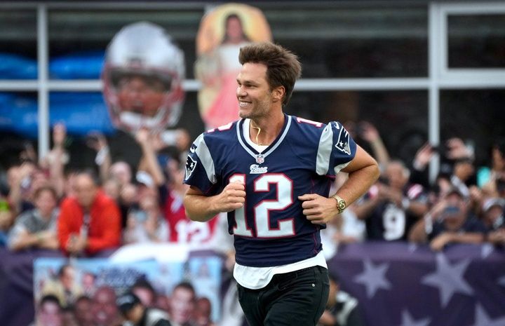 Former New England Patriots quarterback, Tom Brady, runs on to the field at Gillette Stadium on Sunday evening to welcome fans as the Patriots announce they will induct him into the Patriots Hall of Fame in June.