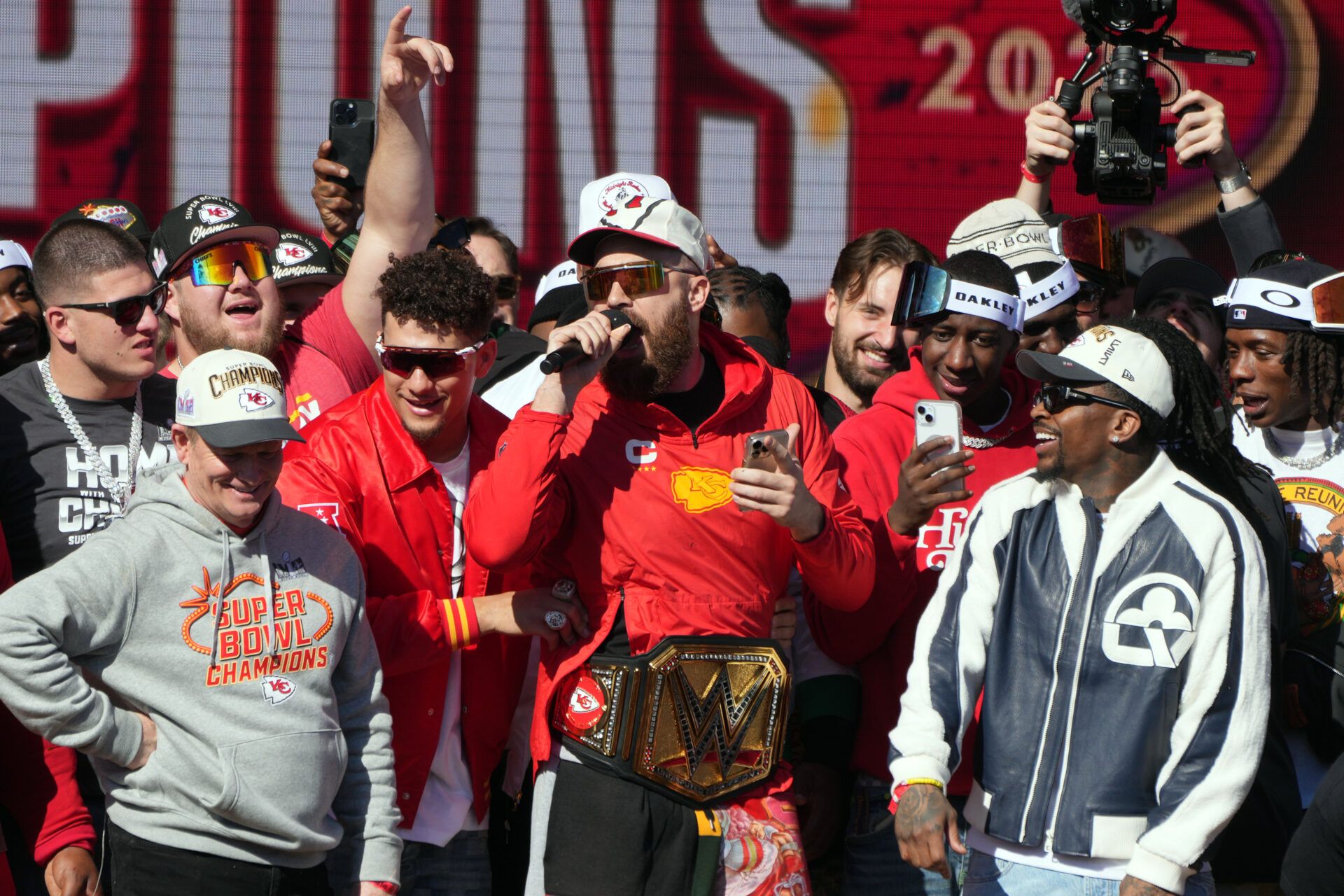 Kansas City Chiefs tight end Travis Kelce (87) addresses the crowd on stage during the celebration of the Kansas City Chiefs winning Super Bowl LVIII.