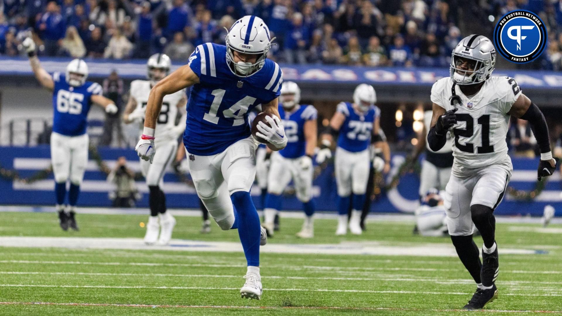 Indianapolis Colts wide receiver Alec Pierce (14) runs for a touchdown while Las Vegas Raiders cornerback Amik Robertson (21) defends in the first half at Lucas Oil Stadium.