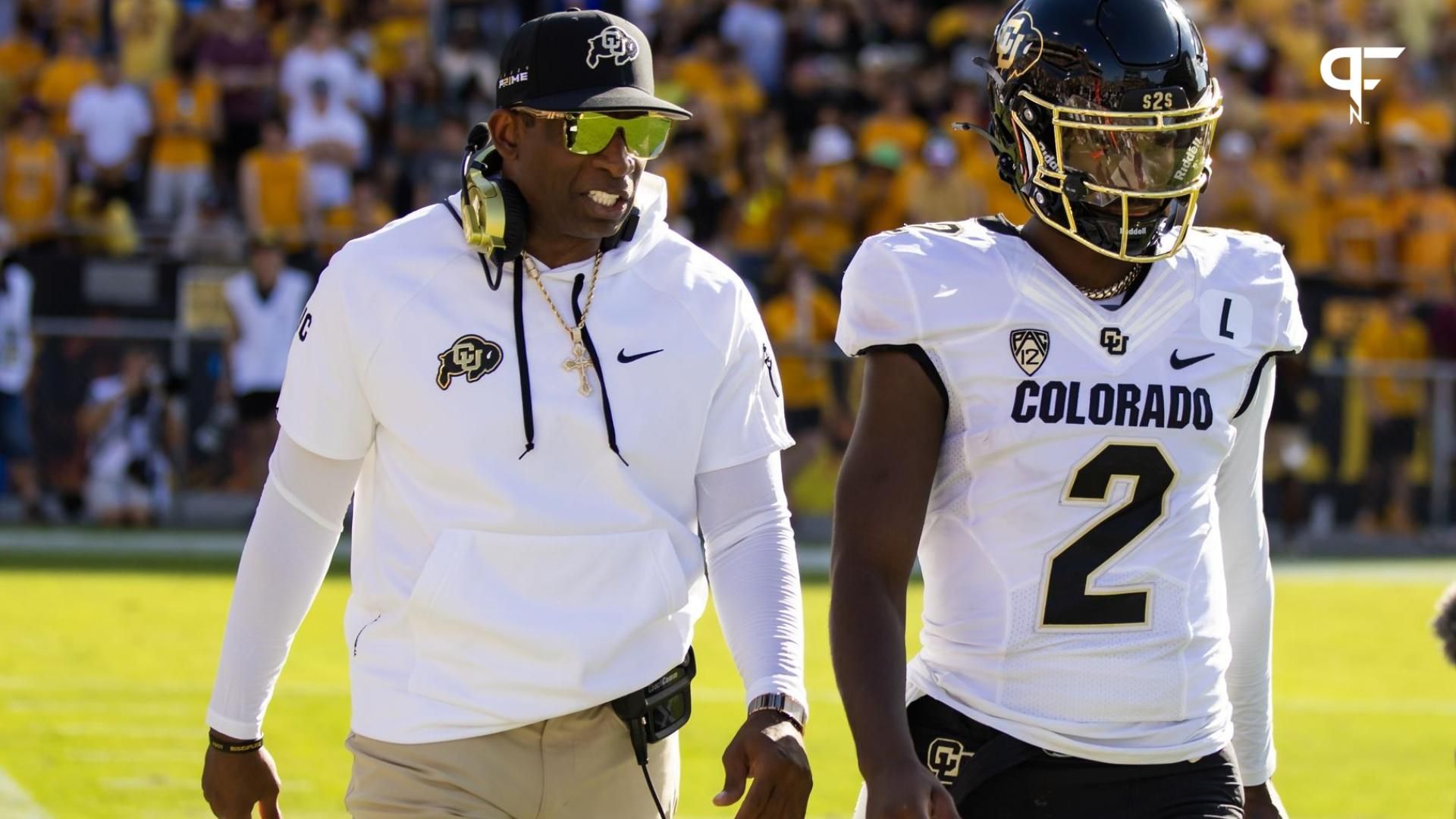 Colorado Buffaloes head coach talks to quarterback Shedeur Sanders (2) on the sidelines.