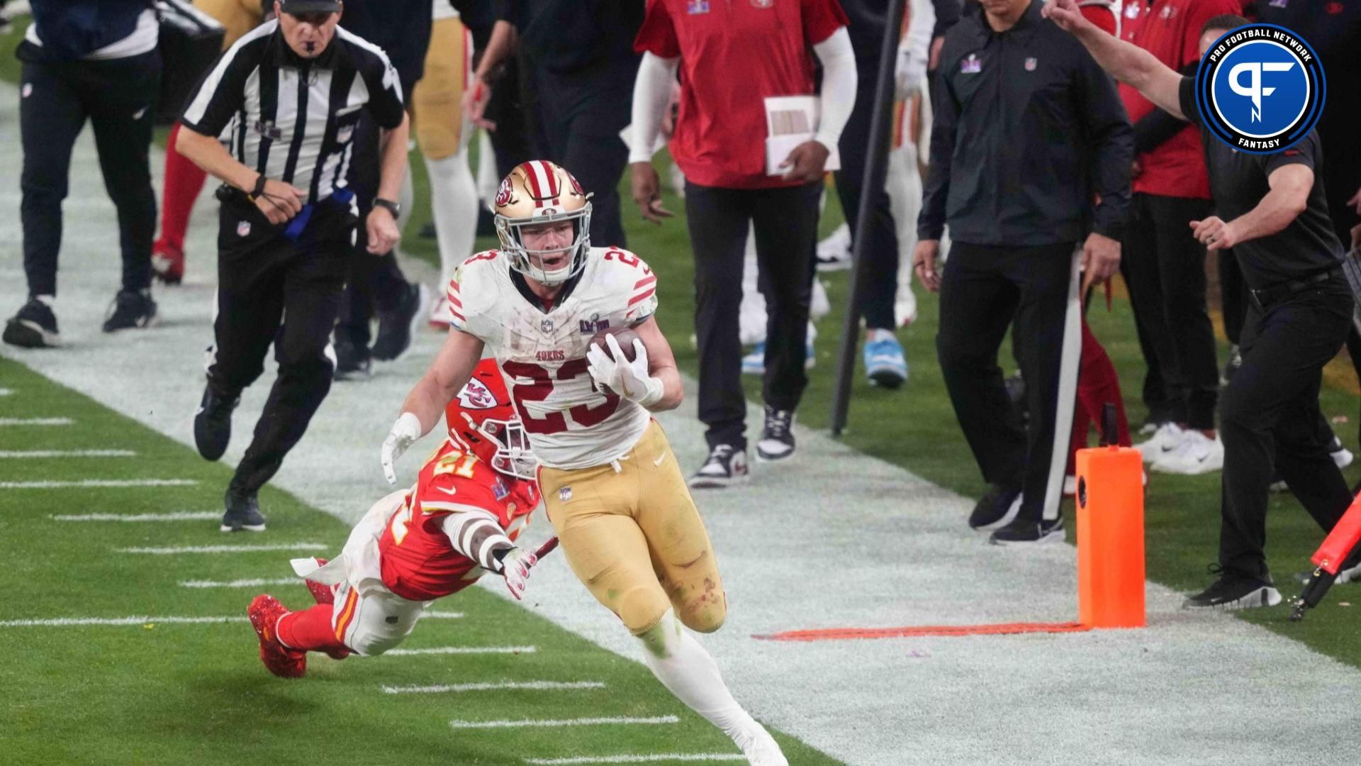 San Francisco 49ers running back Christian McCaffrey (23) runs with the ball against Kansas City Chiefs safety Mike Edwards (21) during overtime of Super Bowl LVIII at Allegiant Stadium.