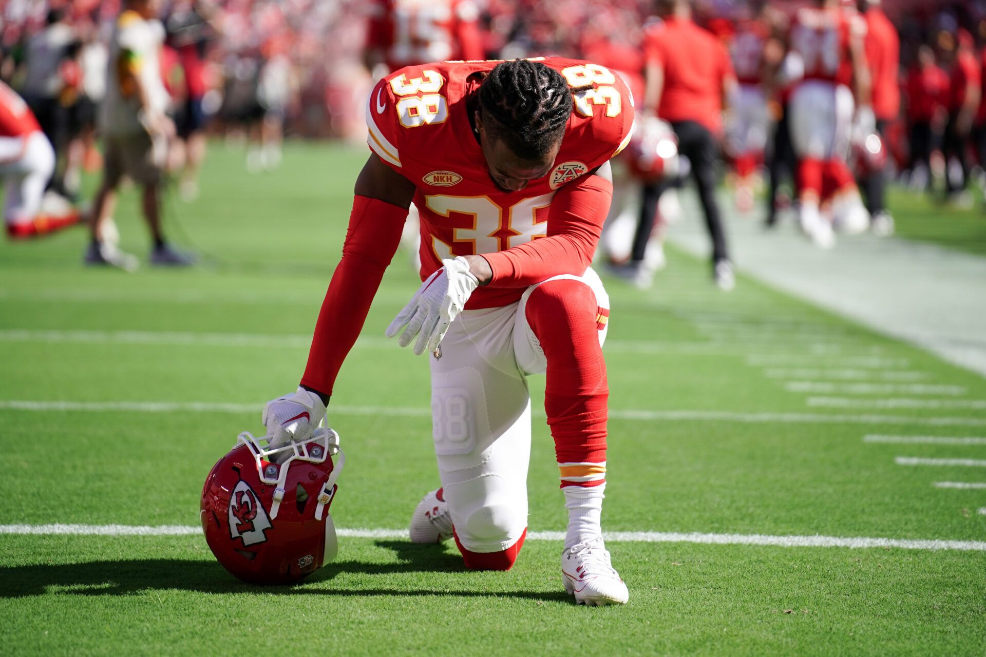 Kansas City Chiefs cornerback L'Jarius Sneed (38) kneels on field against the Chicago Bears prior to a game at GEHA Field at Arrowhead Stadium.