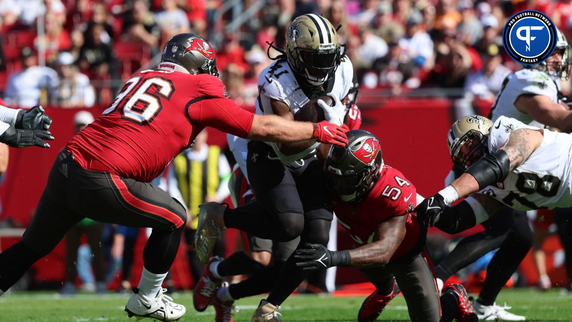 New Orleans Saints running back Alvin Kamara (41) runs with the ball as Tampa Bay Buccaneers defensive tackle Greg Gaines (96) and linebacker Lavonte David (54) tackle during the first quarter at Raymond James Stadium.