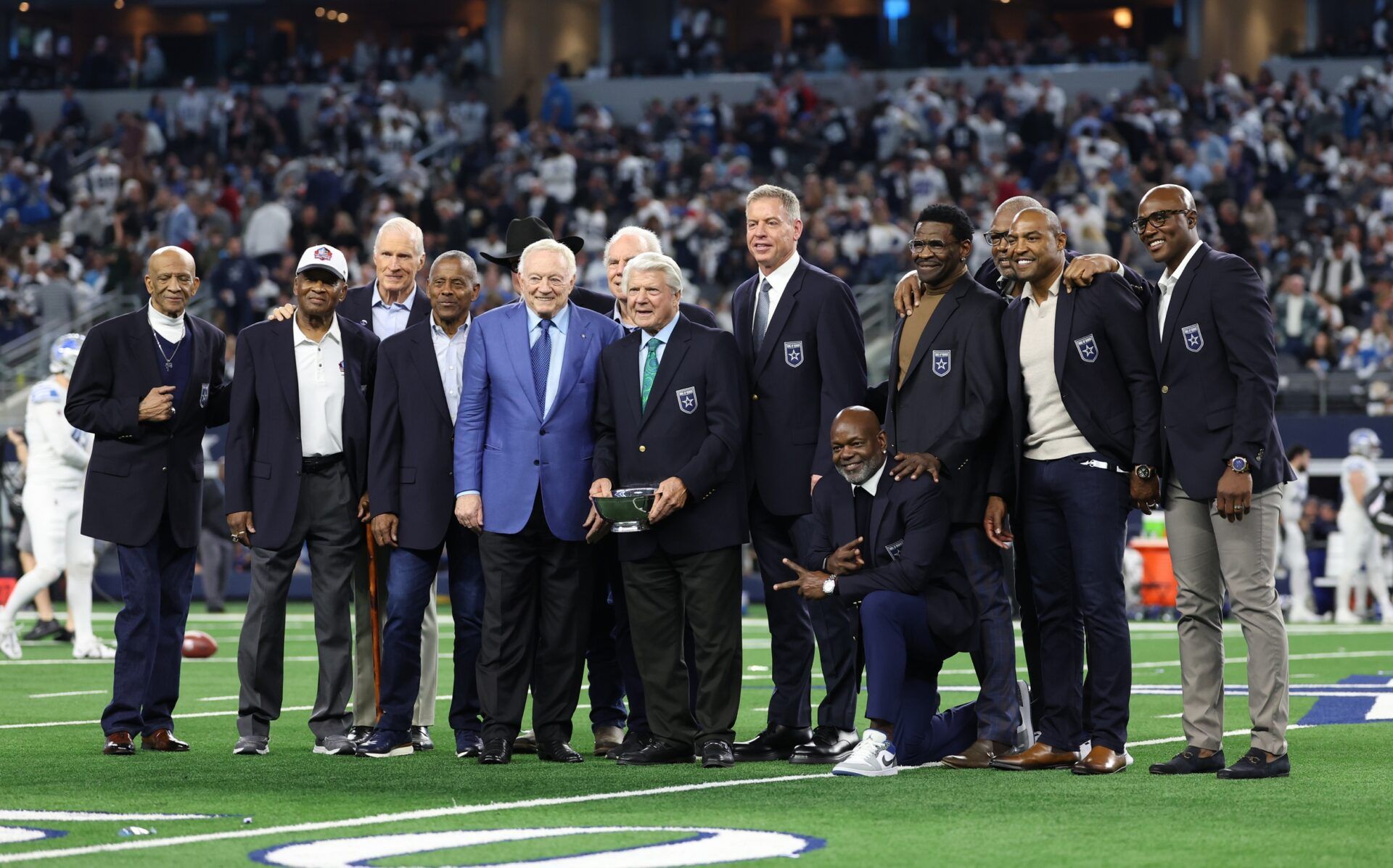 Dallas Cowboys former head coach Jimmy Johnson poses for a photo with former players and owner Jerry Jones after being inducted into the ring of honor at halftime of the game against the Detroit Lions at AT&T Stadium.