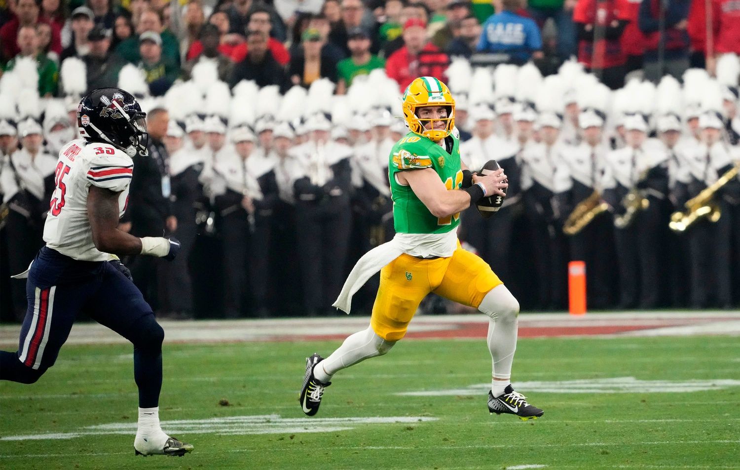 Oregon Ducks quarterback Bo Nix (10) runs for a first down past Liberty Flames linebacker Tyren Dupree (35) in the first half during the Fiesta Bowl at State Farm Stadium in Glendale on Jan. 1, 2024.