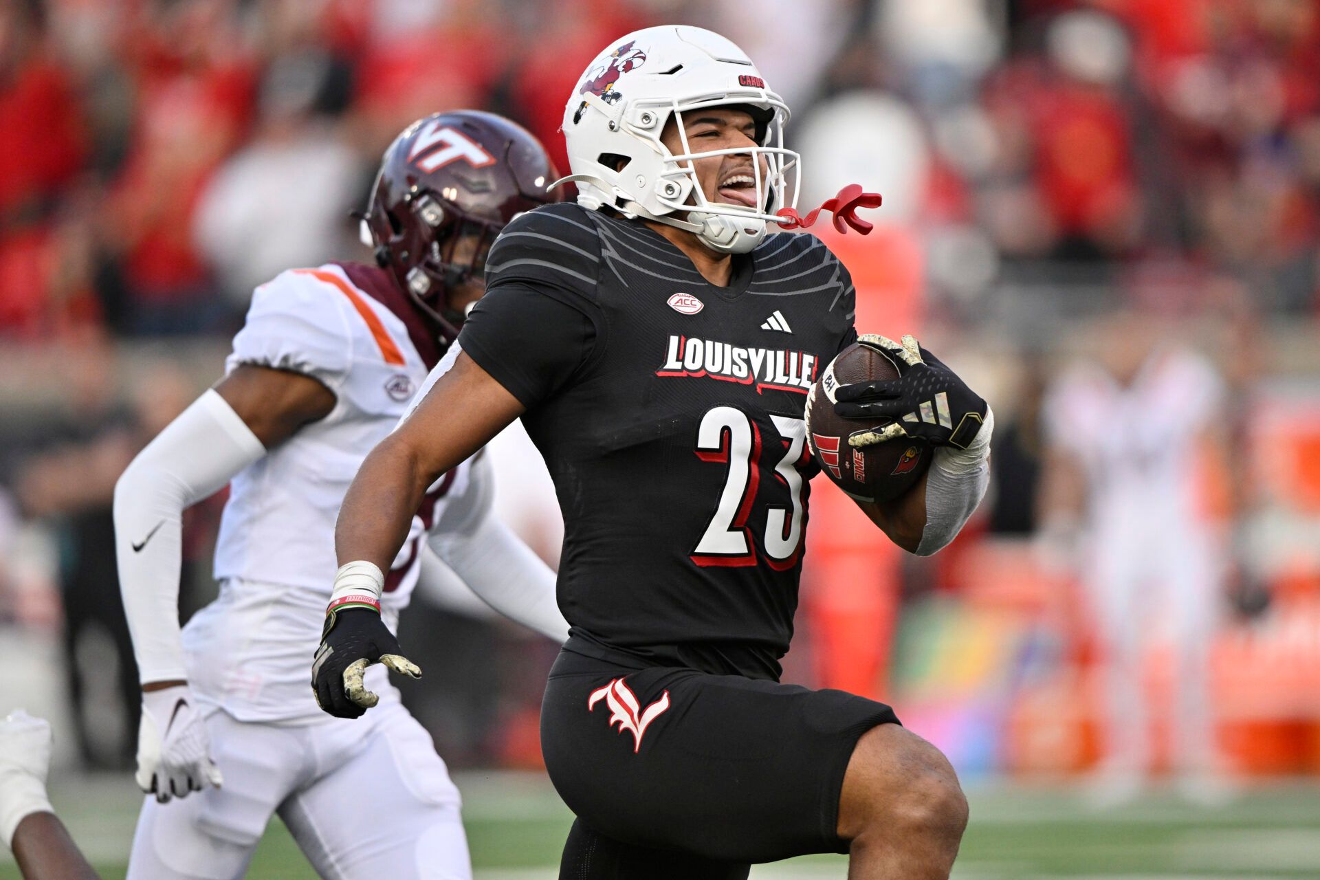 Louisville Cardinals running back Isaac Guerendo (23) runs the ball against Virginia Tech Hokies cornerback Braylon Johnson (8) to score a touchdown during the second half at L&N Federal Credit Union Stadium.