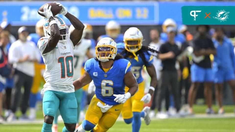 Miami Dolphins wide receiver Tyreek Hill (10) hangs on to the ball for a complete pass and first down in front of Los Angeles Chargers linebacker Eric Kendricks (6) in the first half at SoFi Stadium.