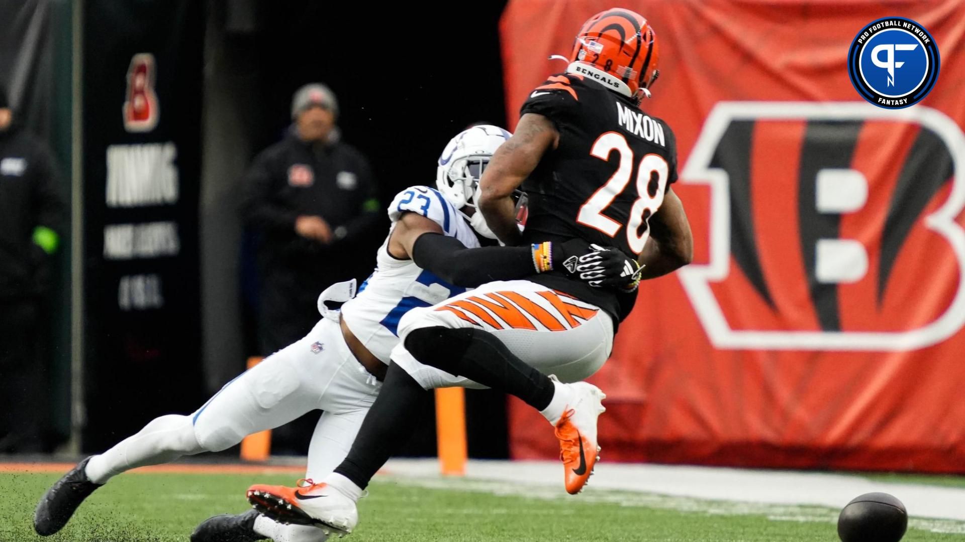 Bengals Joe Mixon (28) is taken down by Colts cornerback Kenny Moore II (23) during the Bengals vs. Colts game at Paycor Stadium on Sunday December 10, 2023. The game was tied 14-14 at halftime.