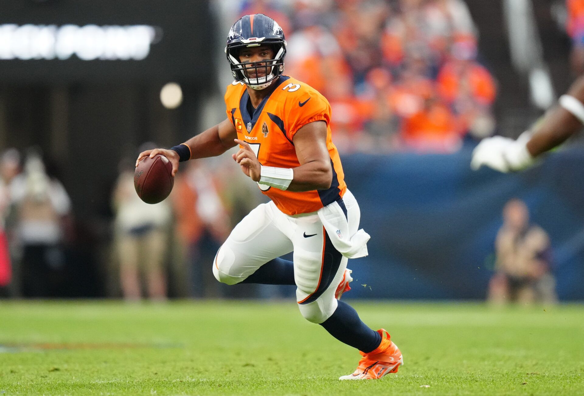 Denver Broncos QB Russell Wilson (3) scrambles with the ball against the Las Vegas Raiders.