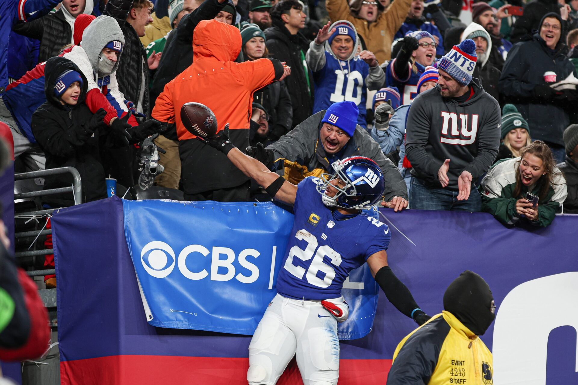 New York Giants running back Saquon Barkley (26) gives the game ball to a young fan after scoring his second touchdown of the game during the first half against the Philadelphia Eagles at MetLife Stadium.