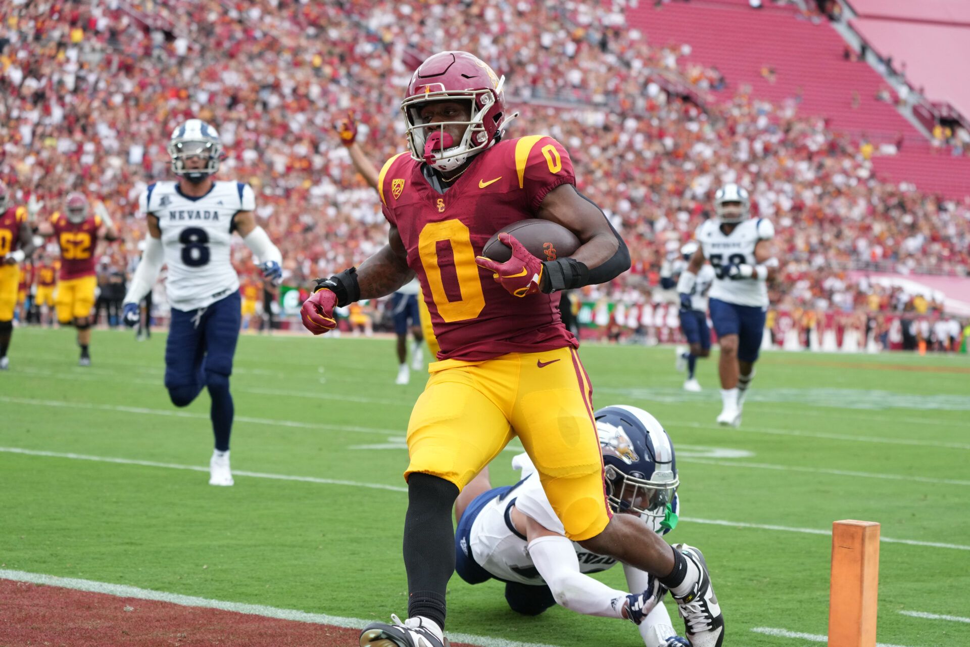 Southern California Trojans running back MarShawn Lloyd (0) scores on a 24-yard touchdown run against Nevada Wolf Pack defensive back KK Meier (10) in the first half at United Airlines Field at Los Angeles Memorial Coliseum.