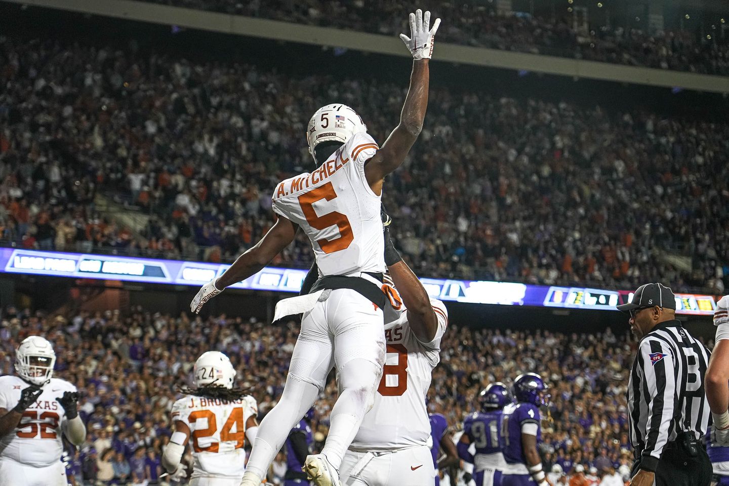 Texas Longhorns offensive lineman Kelvin Banks Jr. (78) lifts wide receiver Adonai Mitchell (5) to celebrate a touchdown against the TCU Horned Frogs at Amon G. Carter Stadium.