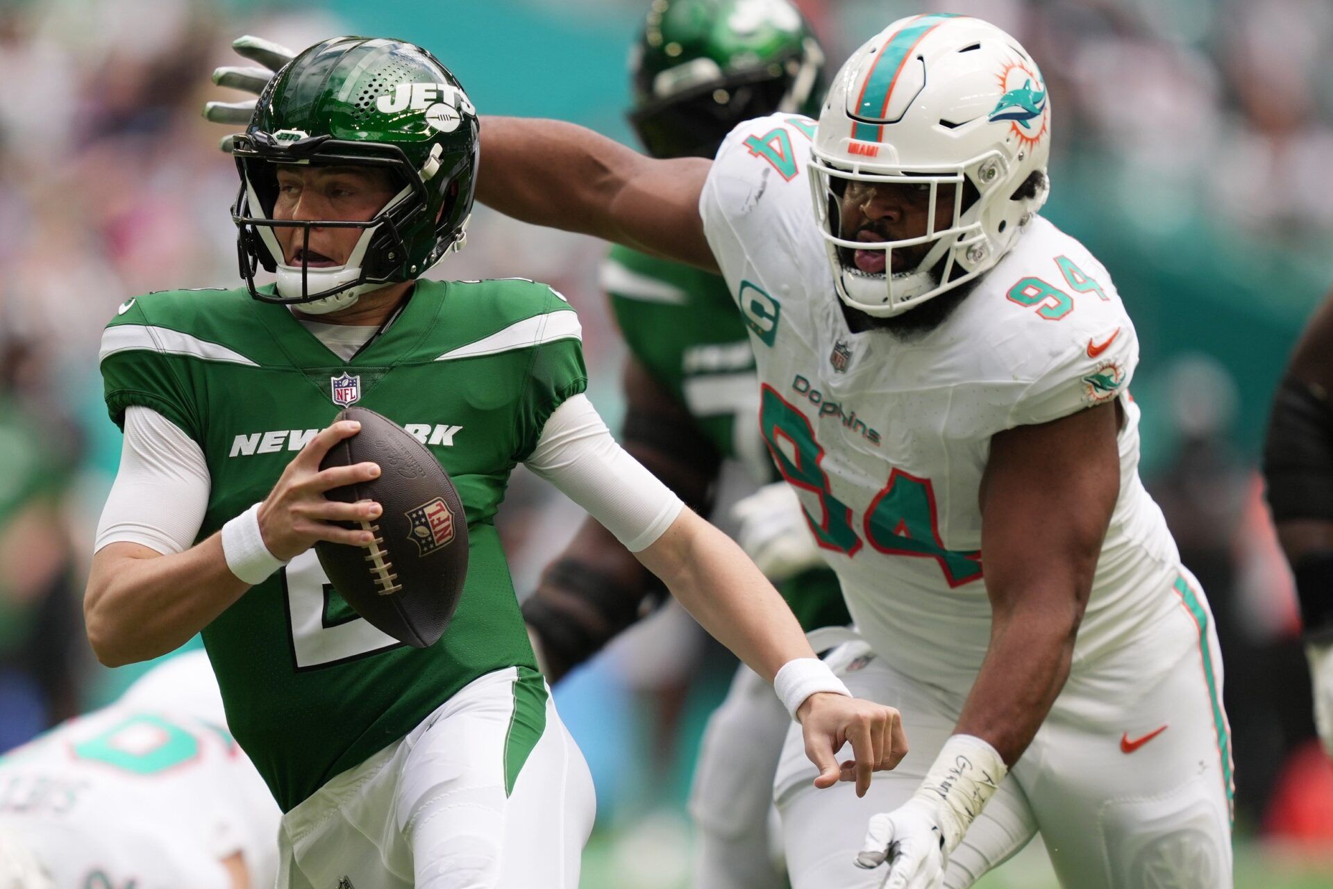 New York Jets quarterback Zach Wilson tries to elude the pressure of Miami Dolphins defensive tackle Christian Wilkins during the first half at Hard Rock Stadium in Miami Gardens, Dec. 17, 2023.