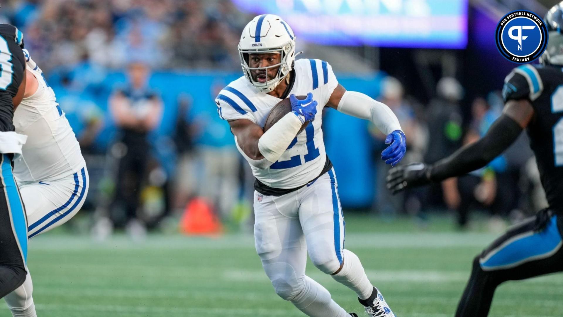 Indianapolis Colts running back Zack Moss (21) runs through an opening defended by Carolina Panthers defensive tackle LaBryan Ray (93) during the first quarter at Bank of America Stadium.