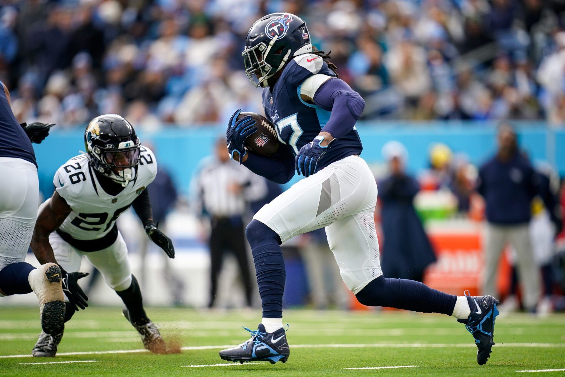 Tennessee Titans running back Derrick Henry (22) runs the ball towards Jacksonville Jaguars safety Antonio Johnson (26) during the first quarter at Nissan Stadium in Nashville, Tenn., Sunday, Jan. 7, 2024.