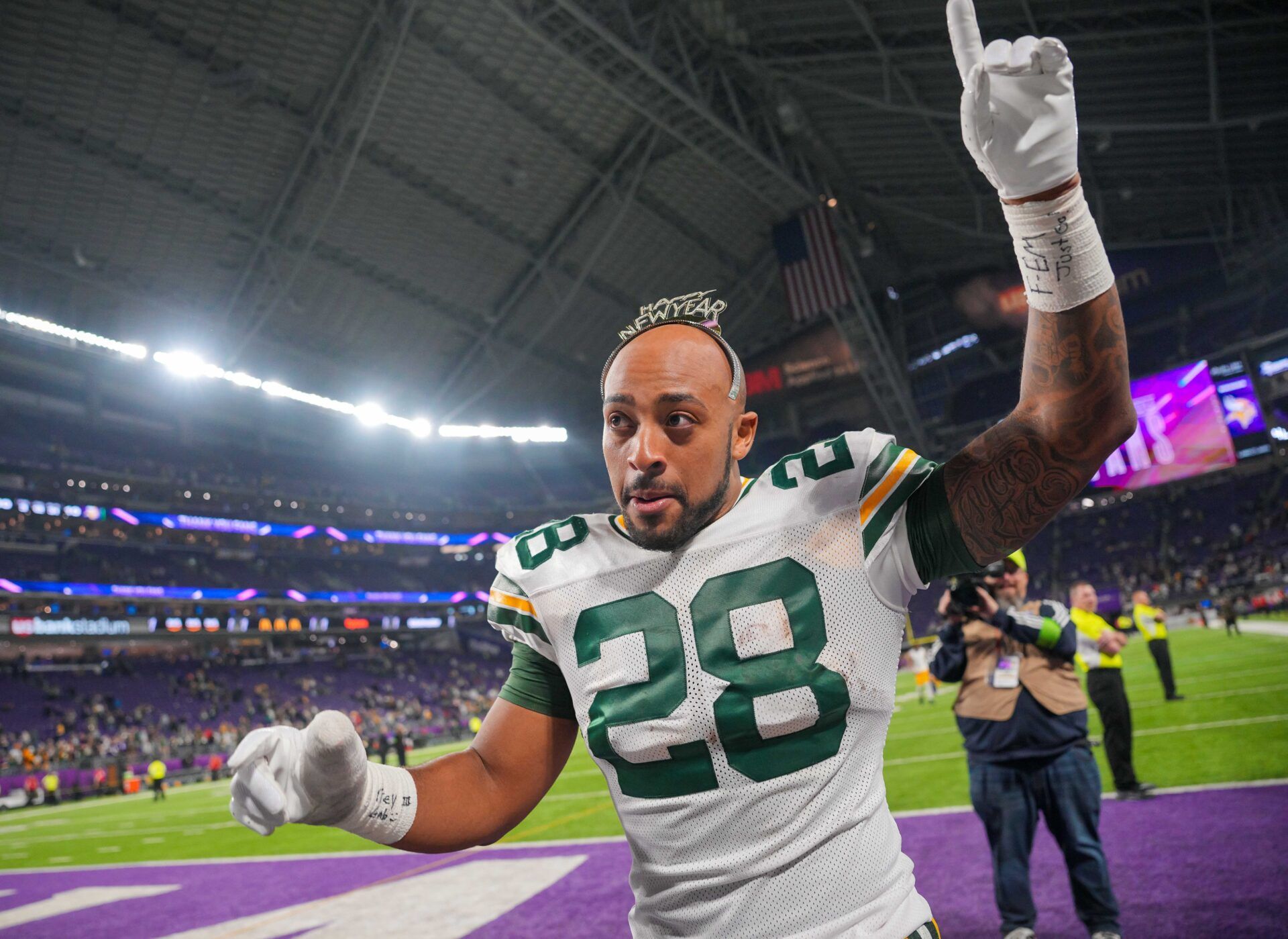 Green Bay Packers running back AJ Dillon (28) celebrates with fans wearing a Happy New Year headband after the game against the Minnesota Vikings at U.S. Bank Stadium.