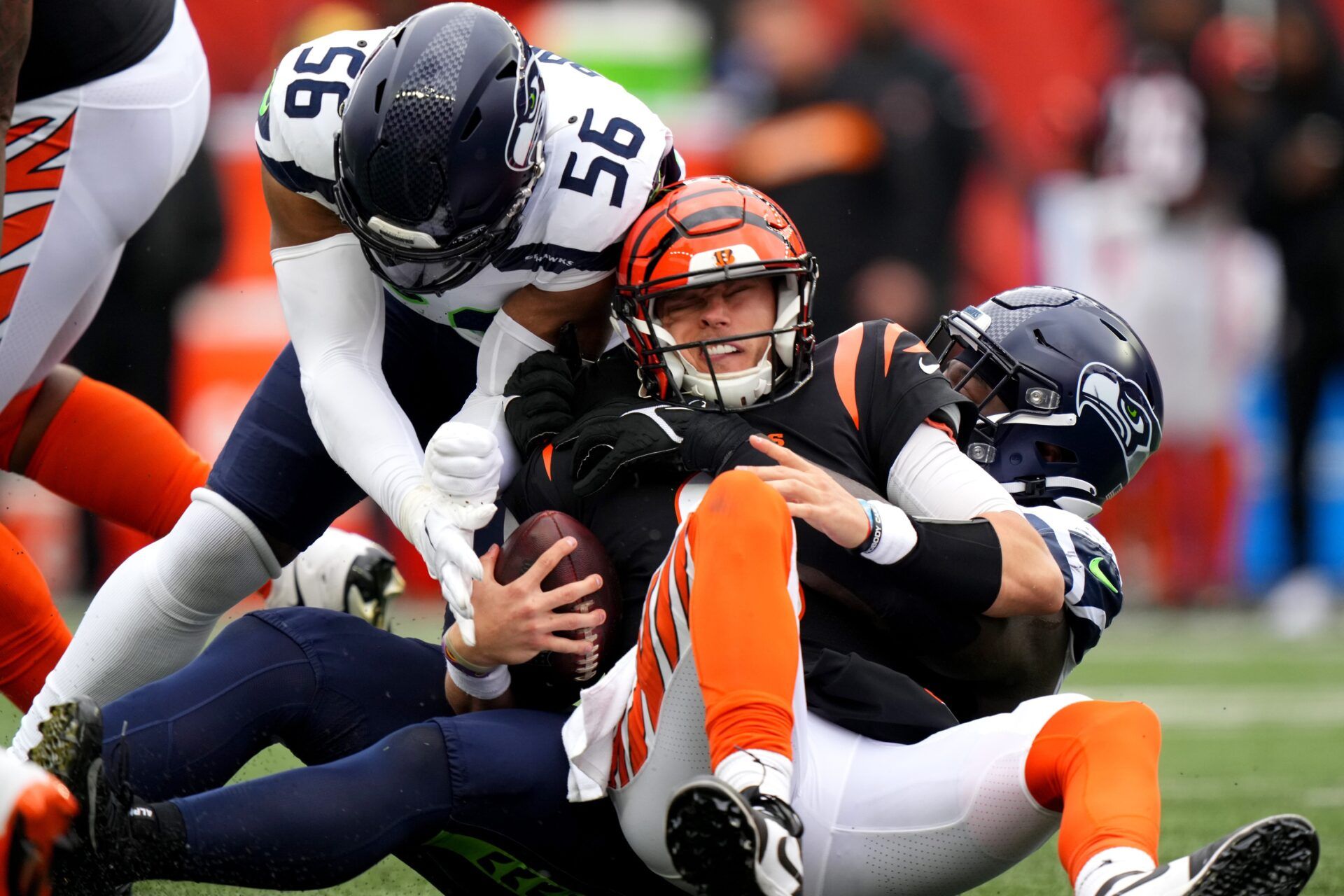 Cincinnati Bengals quarterback Joe Burrow (9) is sacked by Seattle Seahawks defensive tackle Jarran Reed (90) and Seattle Seahawks linebacker Jordyn Brooks (56) in the third quarter during an NFL football game between the Seattle Seahawks and the Cincinnati Bengals Sunday, Oct. 15, 2023, at Paycor Stadium in Cincinnati.