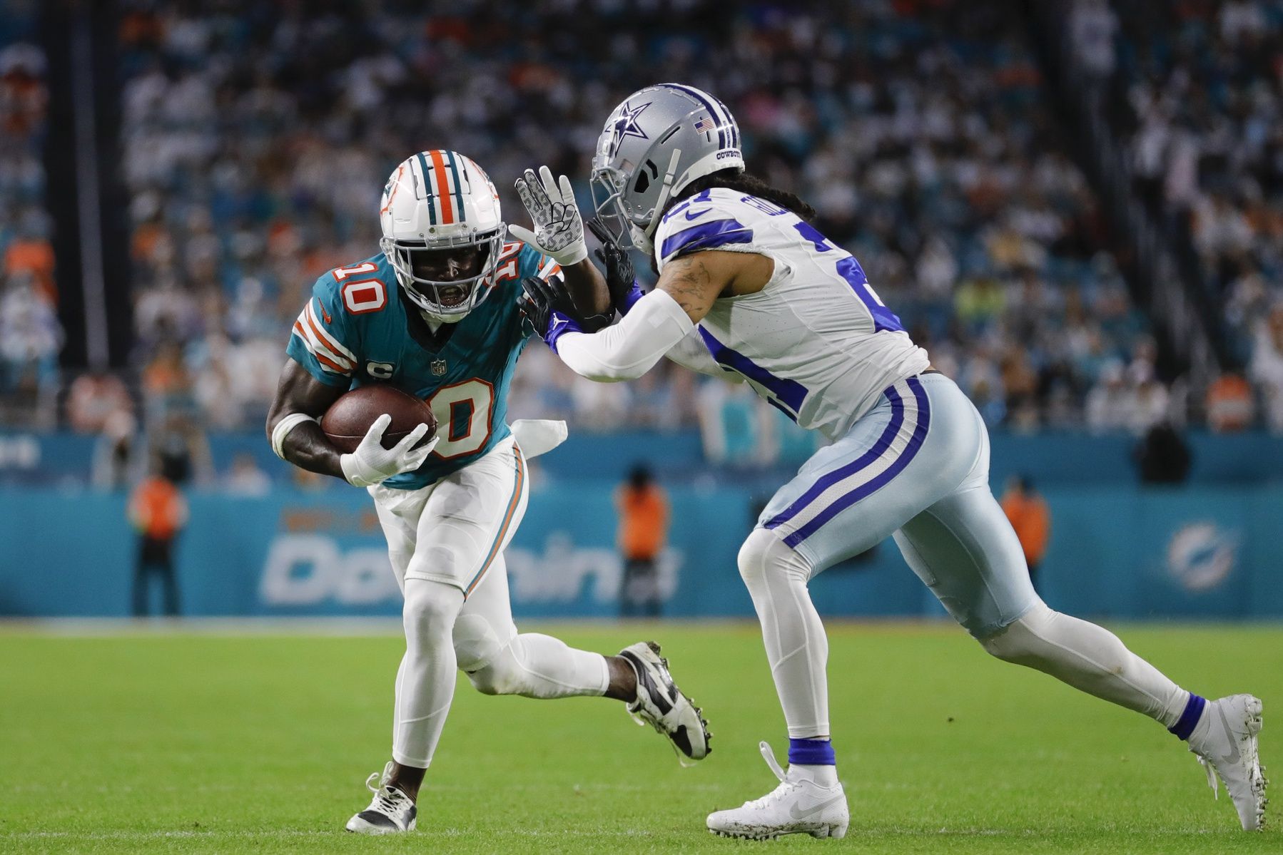 Miami Dolphins wide receiver Tyreek Hill (10) runs with the football against Dallas Cowboys cornerback Stephon Gilmore (21) during the second quarter at Hard Rock Stadium.