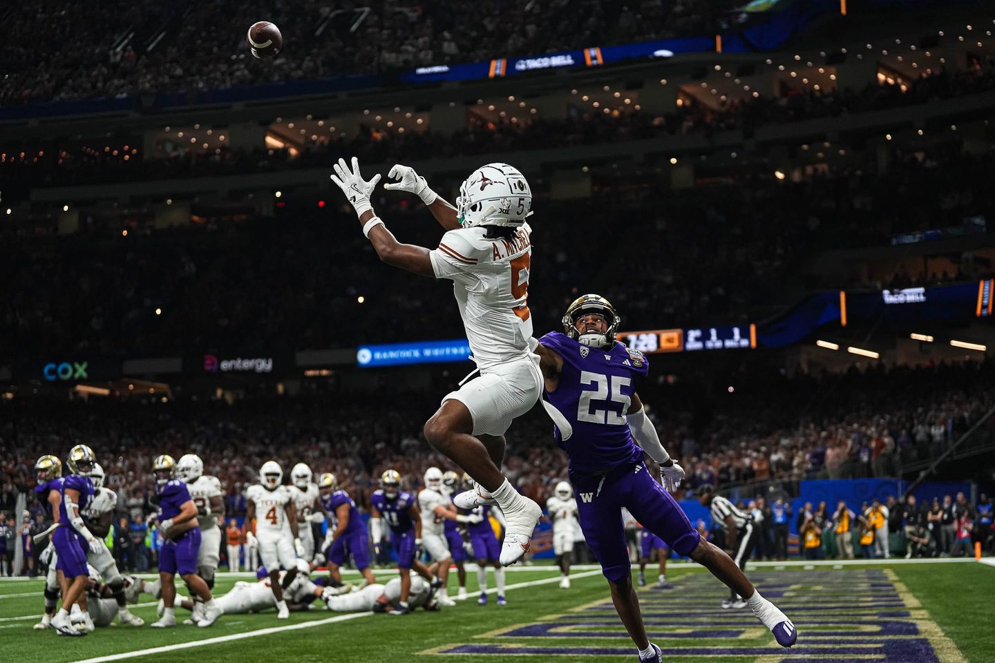 Texas Longhorns wide receiver Adonai Mitchell (5) makes a touchdown catch over Washington cornerback Elijah Jackson during the Sugar Bowl College Football Playoff semifinals game at the Caesars Superdome on Monday, Jan. 1, 2024 in New Orleans, Louisiana. The catch would be the last touchdown for the Longhorns in the 31-37 loss to Washington.