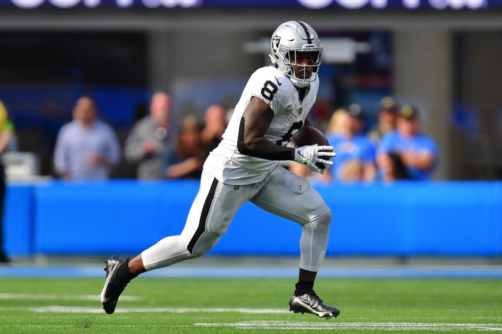 Las Vegas Raiders running back Josh Jacobs (8) runs the ball against the Los Angeles Chargers during the second half at SoFi Stadium.