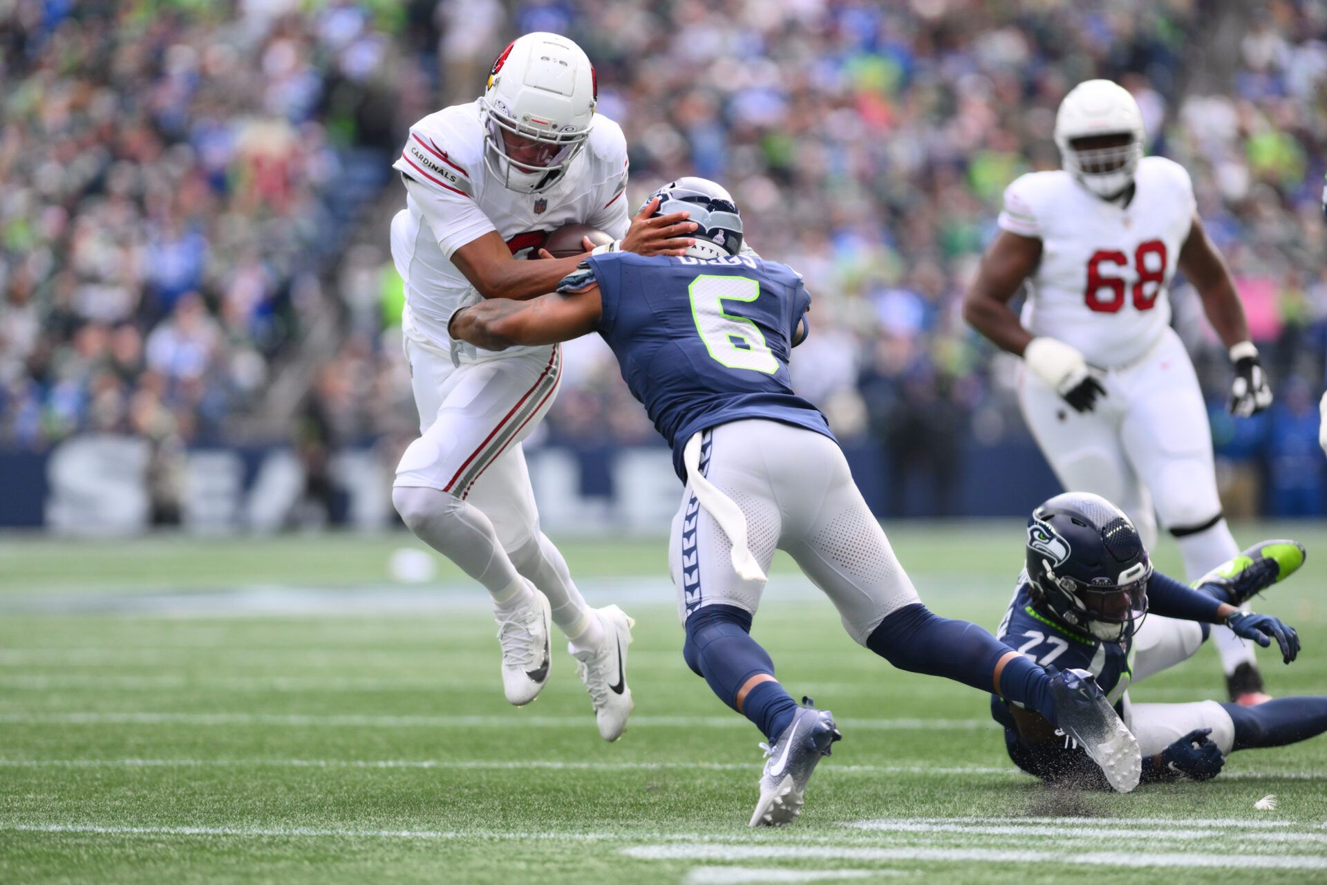 Arizona Cardinals quarterback Joshua Dobbs (9) breaks a tackle attempt by Seattle Seahawks safety Quandre Diggs (6) to later run the ball in for a touchdown during the first half at Lumen Field.