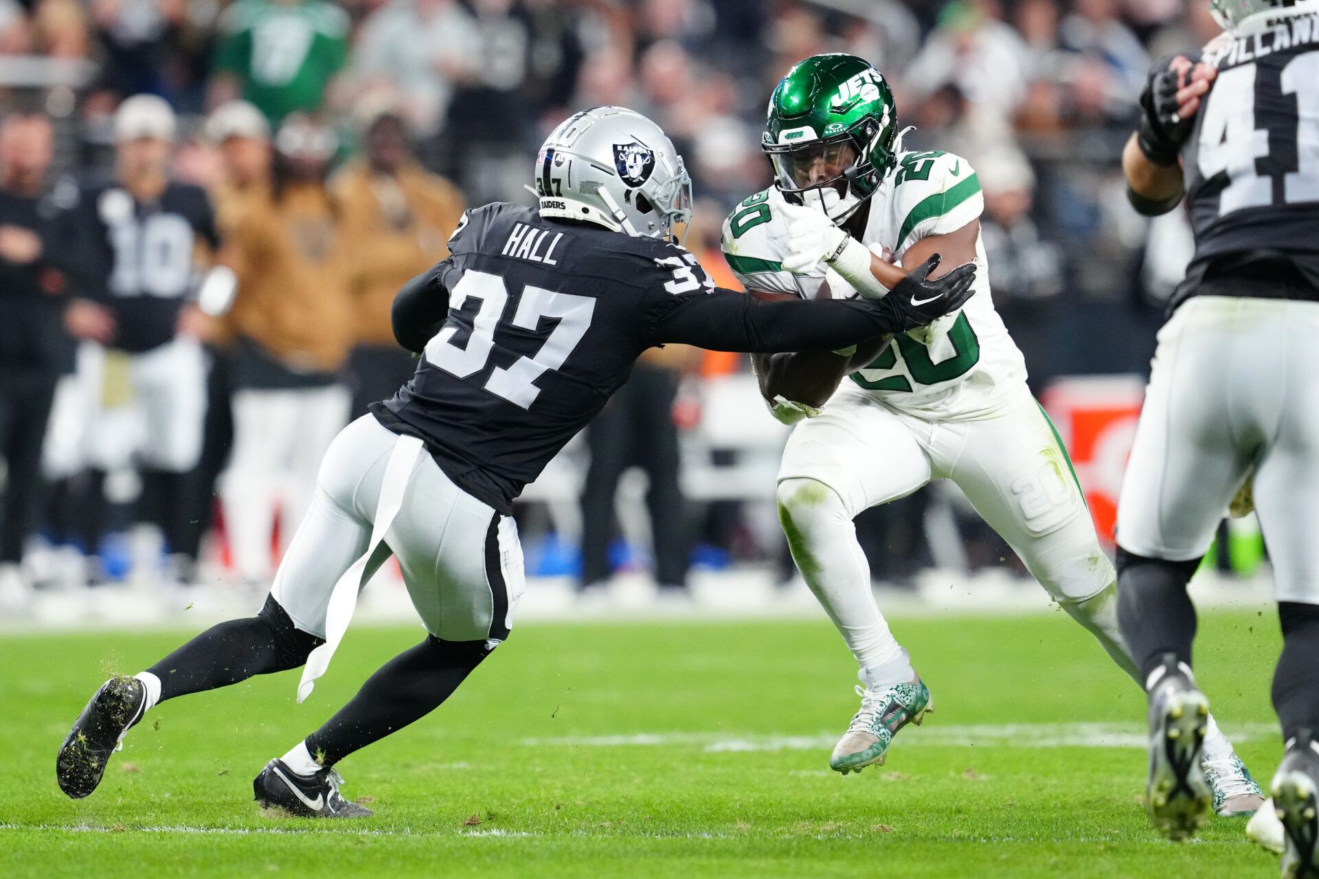 New York Jets running back Breece Hall (20) is tackled by Las Vegas Raiders cornerback Tyler Hall (37) during the fourth quarter at Allegiant Stadium.