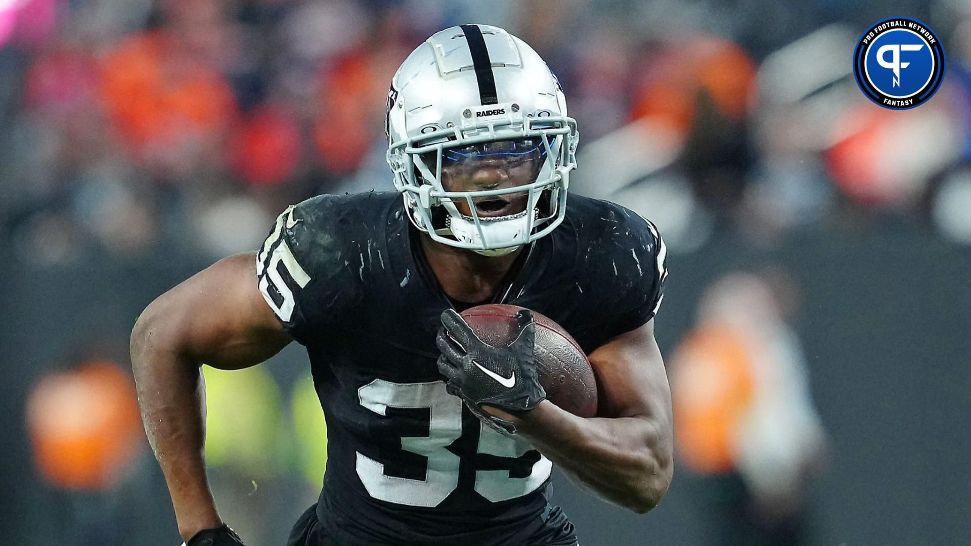 Las Vegas Raiders running back Zamir White (35) gains yardage against the Denver Broncos during the fourth quarter at Allegiant Stadium.