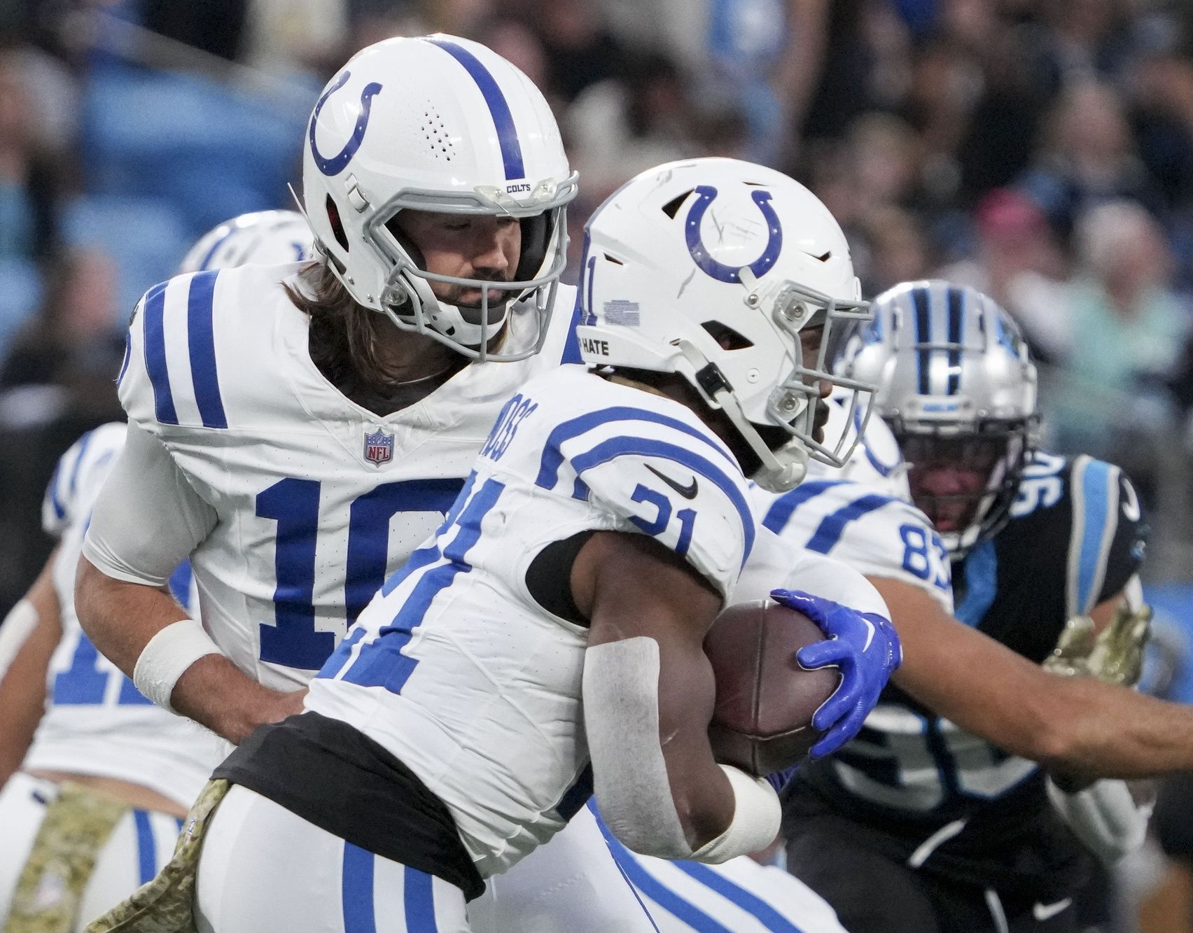 Indianapolis Colts quarterback Gardner Minshew II (10) hands the ball off to Indianapolis Colts running back Zack Moss (21) on Sunday at Bank of America Stadium in Charlotte.