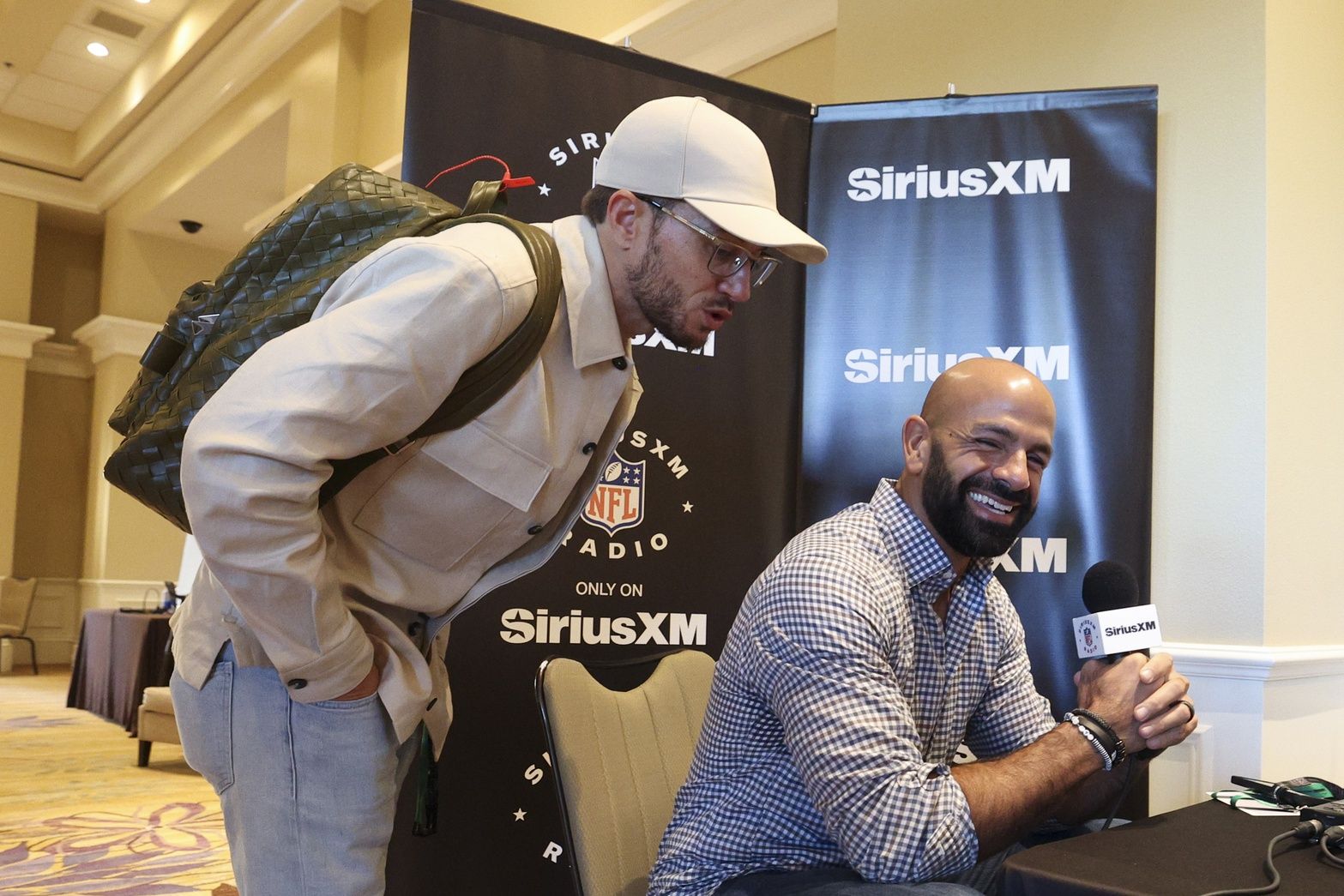 New York Jets head coach Robert Saleh talks to media as Miami Dolphins head coach Mike McDaniel jumps in during the NFL annual league meetings.