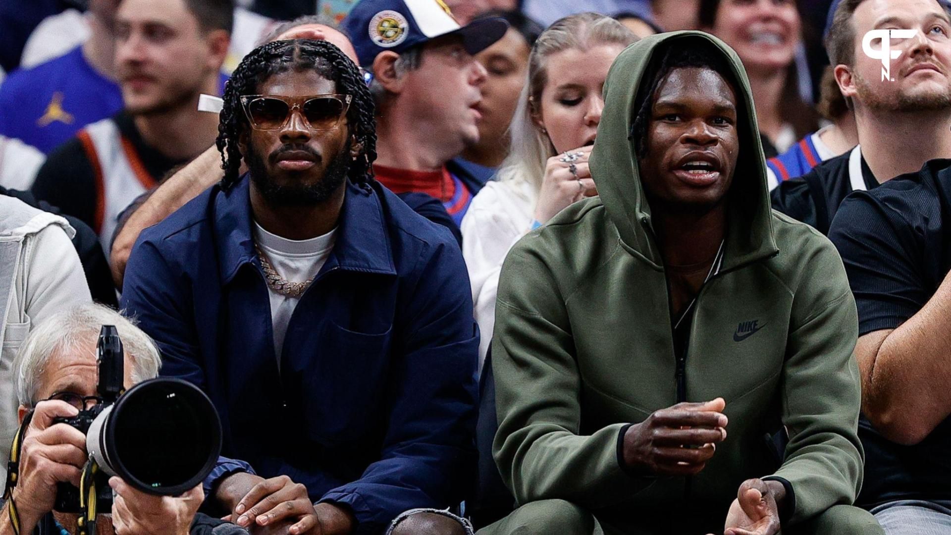 University of Colorado Buffaloes football players Shedeur Sanders (L) and Travis Hunter (R) watch during the third period between the Denver Nuggets and the Los Angeles Lakers at Ball Arena.