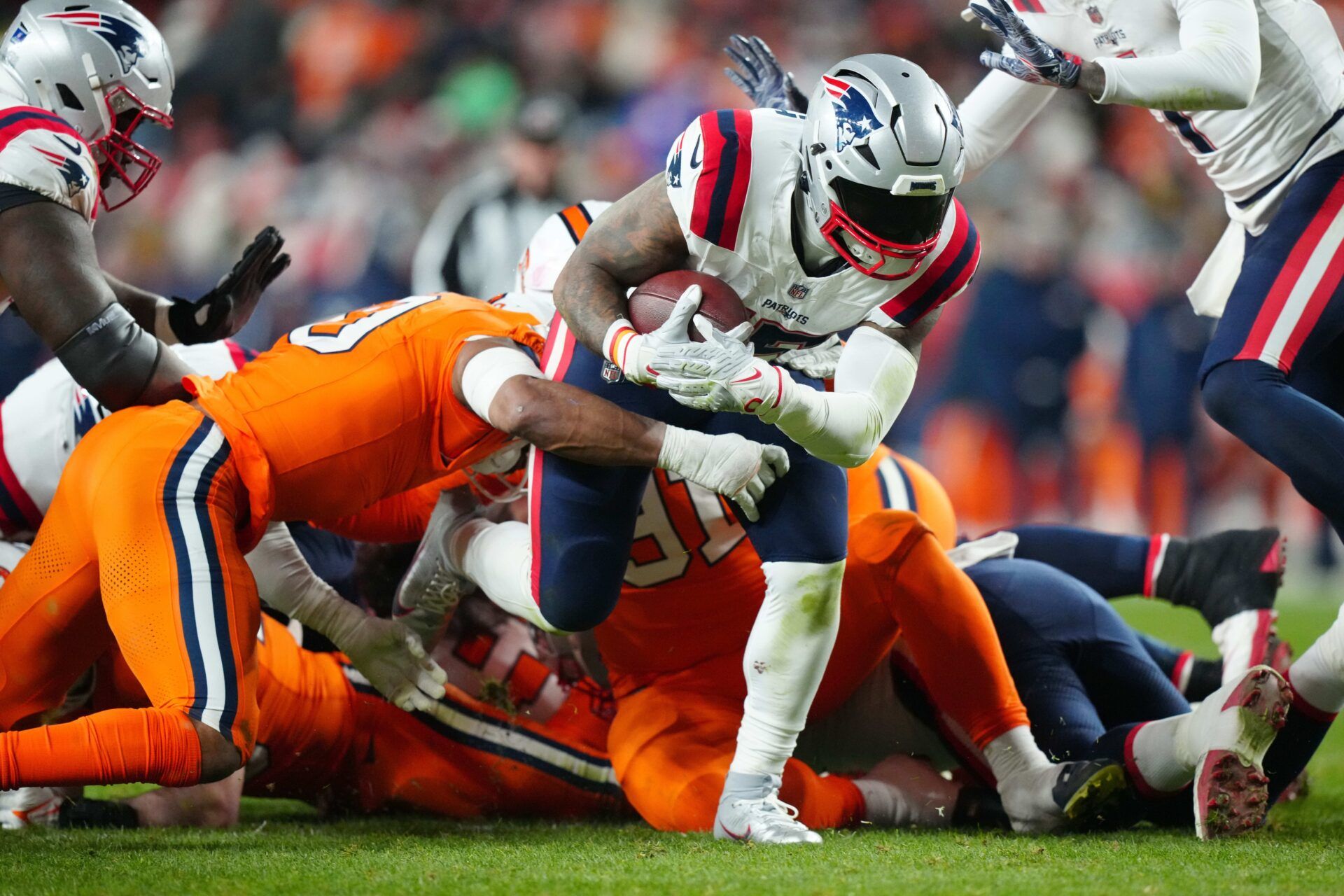 New England Patriots RB Ezekiel Elliott (15) attempts to break a tackle against the Denver Broncos.