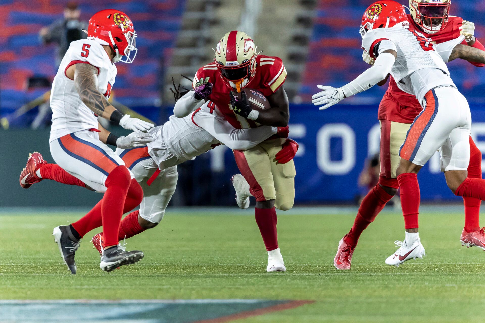 Birmingham Stallions running back CJ Marable (11) runs the ball as New Jersey Generals linebacker D'Juan Hines (4) hits him during the second half of a USFL football game at Protective Stadium.