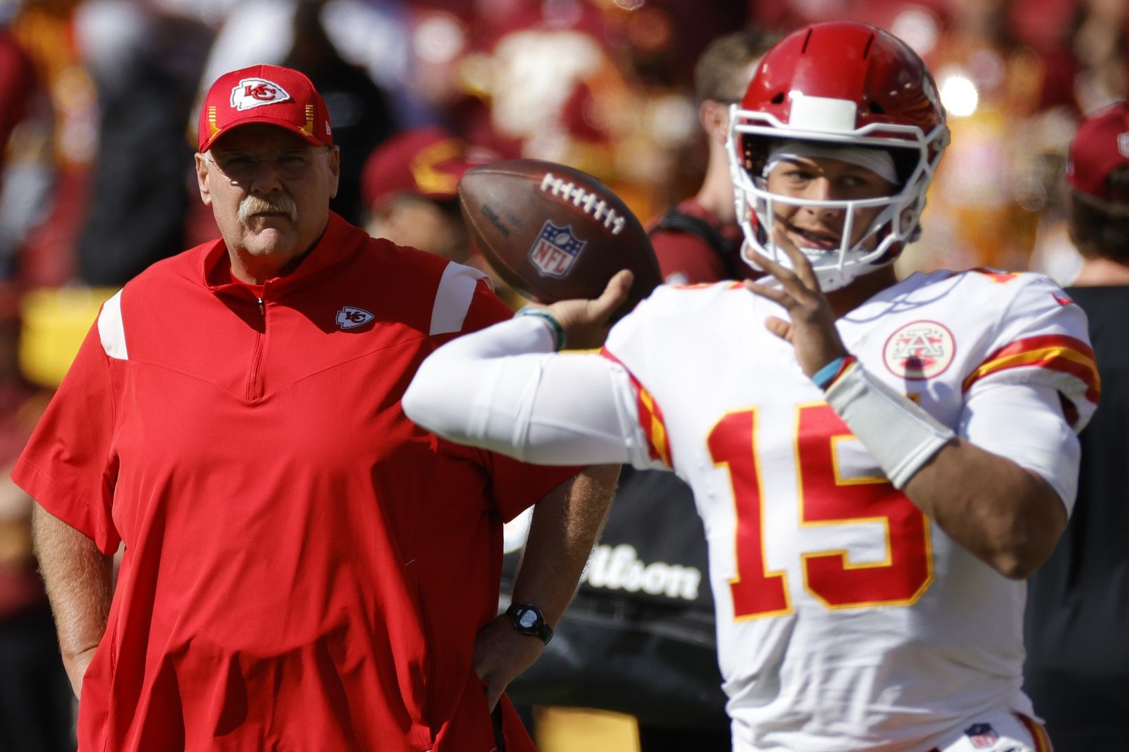 Kansas City Chiefs QB Patrick Mahomes (15) warms up while head coach Andy Reid looks on.