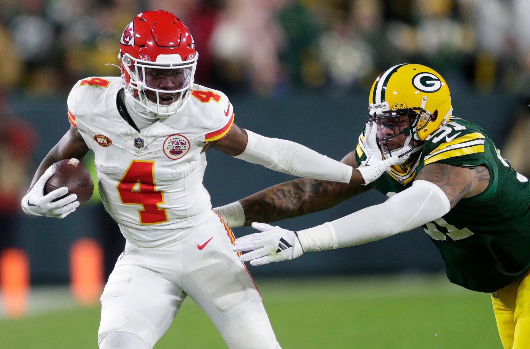 Kansas City Chiefs wide receiver Rashee Rice (4) stiff arms Green Bay Packers linebacker Preston Smith (91) during their football game Sunday, December 3, 2023, at Lambeau Field in Green Bay, Wis.