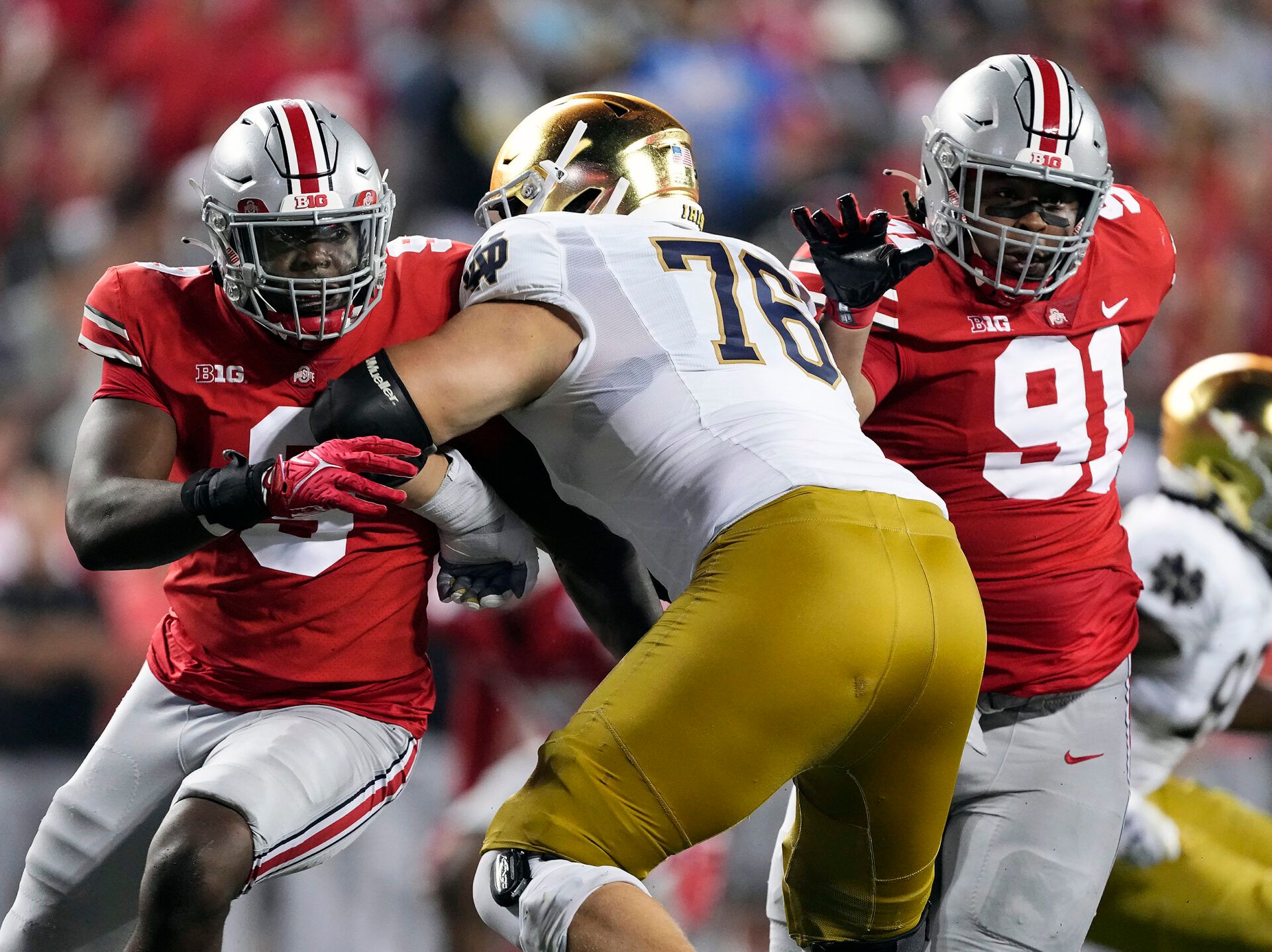 Ohio State Buckeyes defensive end Zach Harrison (9) and Ohio State Buckeyes defensive tackle Tyleik Williams (91) rush against Notre Dame Fighting Irish offensive lineman Joe Alt (76) in the fourth quarter at Ohio Stadium.