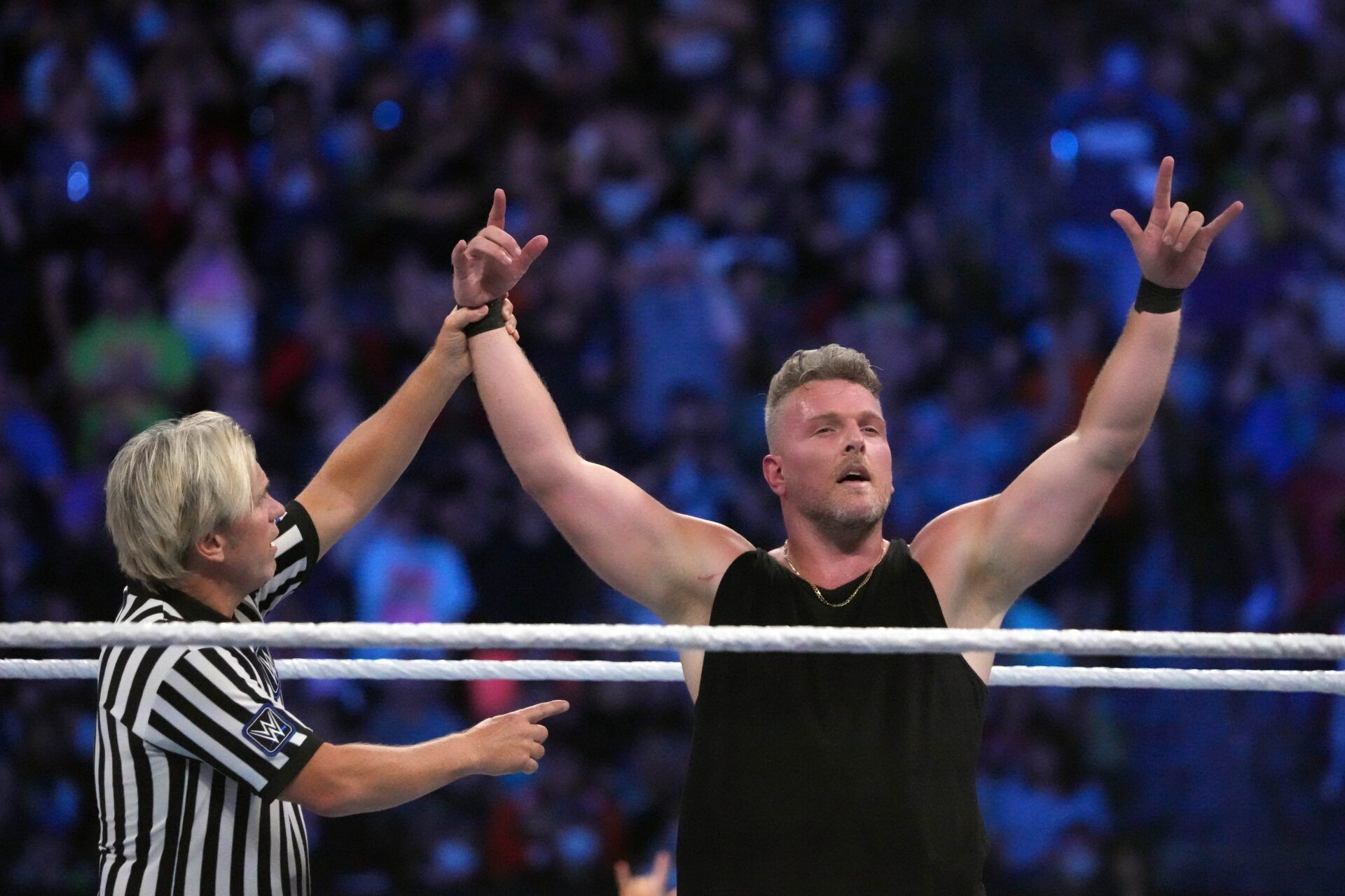 Pat McAfee (black attire) and Happy Corbin (white/blue attire) wrestle during SummerSlam at Nissan Stadium.