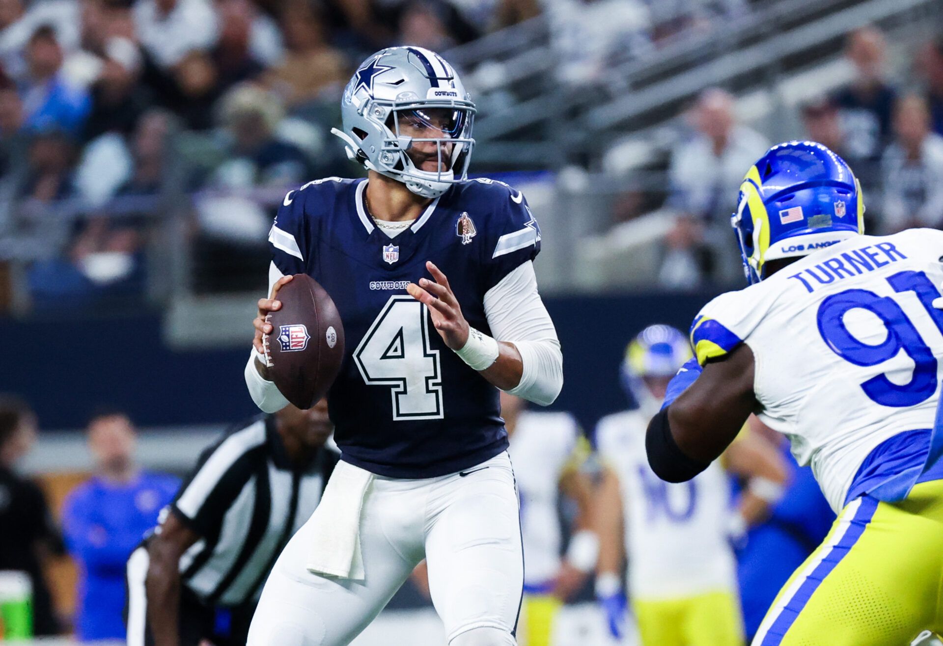 Dallas Cowboys quarterback Dak Prescott (4) looks to pass as Los Angeles Rams defensive tackle Kobie Turner (91) rushes during the first half at AT&T Stadium.