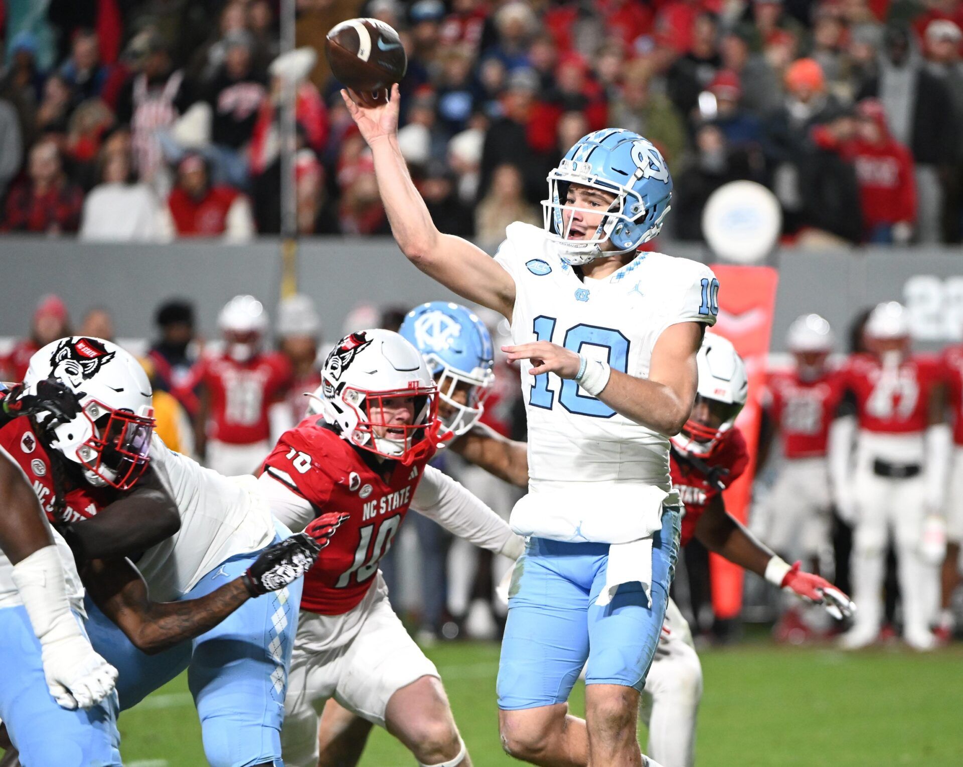 North Carolina Tar Heels quarterback Drake Maye (10) throws a pass against North Carolina State Wolfpack linebacker Caden Fordham during the first half at Carter-Finley Stadium.