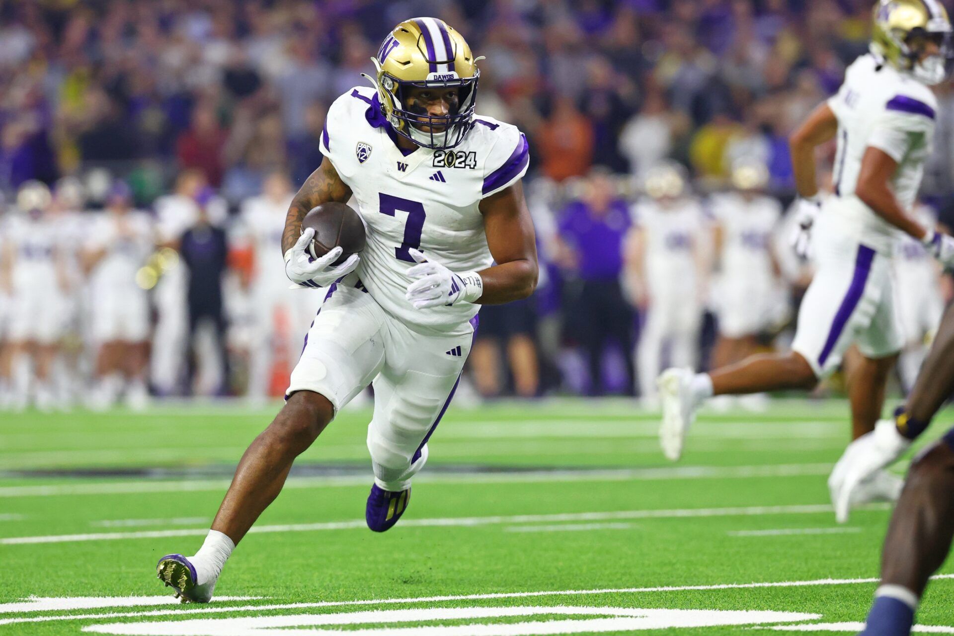 Washington Huskies RB Dillon Johnson (7) runs the ball against the Michigan Wolverines in the national championship.