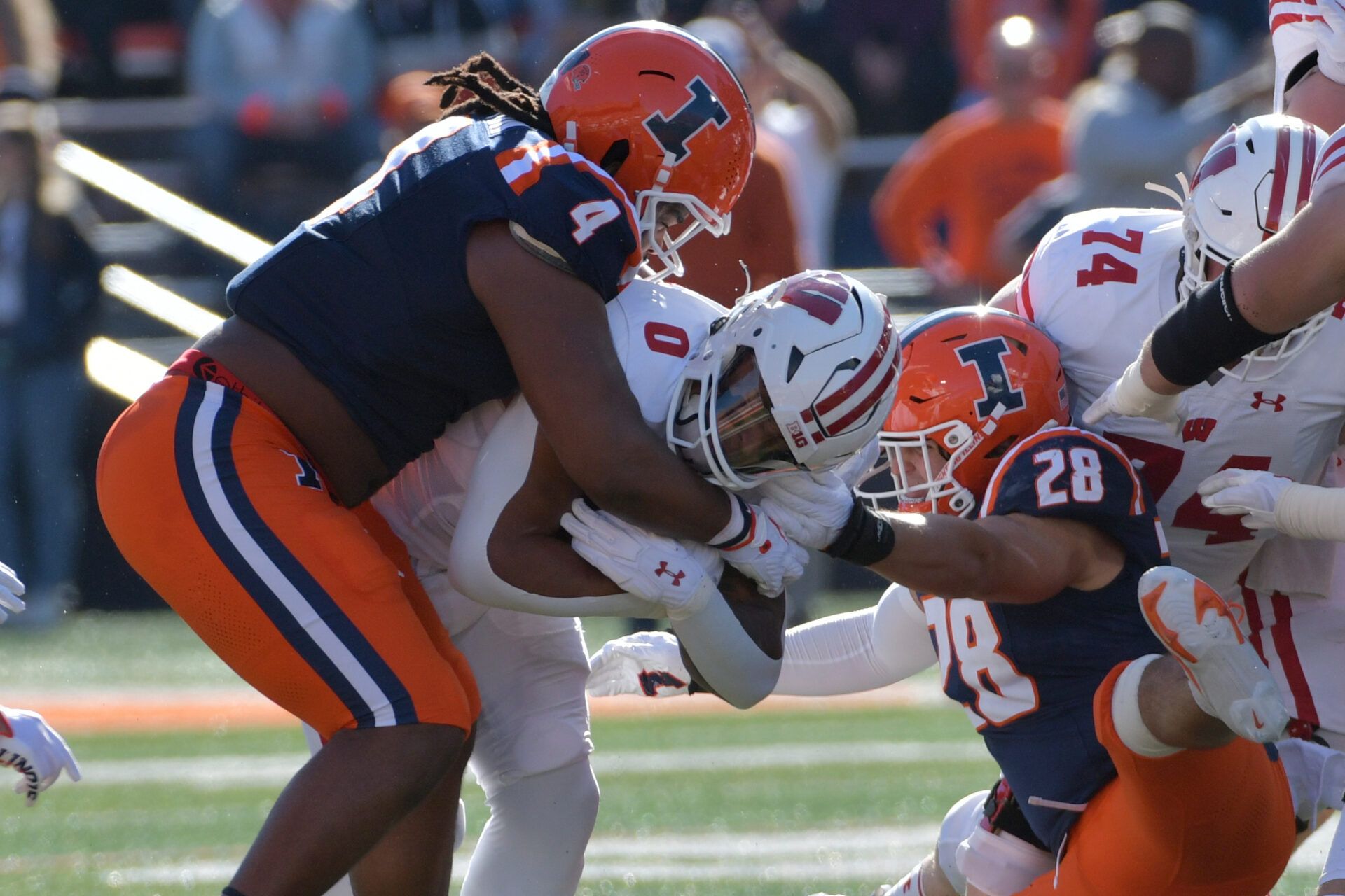 Illinois Fighting Illini defensive tackle Jer'Zhan Newton (4) tackles Wisconsin Badgers running back Braelon Allen (0) during the first half at Memorial Stadium.