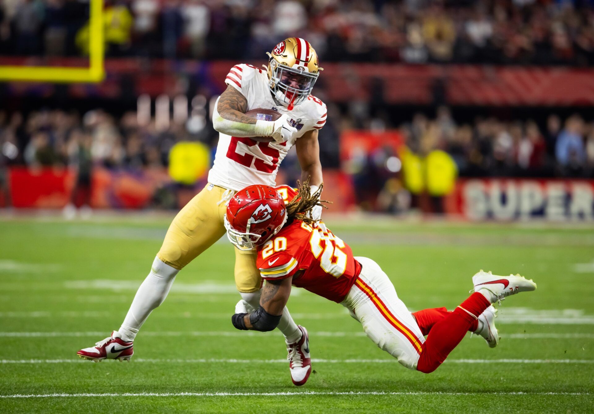 San Francisco 49ers running back Elijah Mitchell (25) is tackled by Kansas City Chiefs safety Justin Reid (20) in Super Bowl LVIII at Allegiant Stadium.