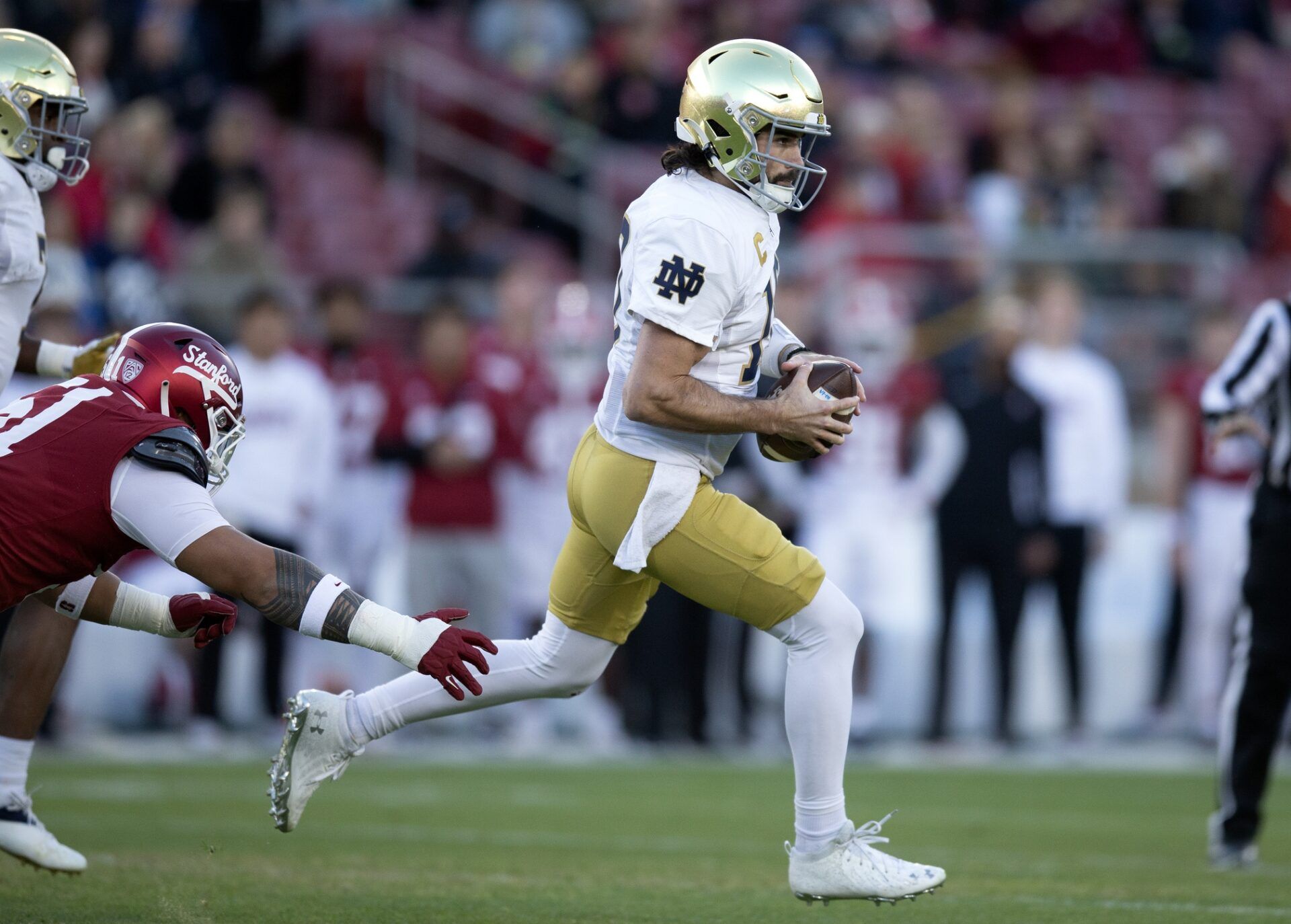 Notre Dame Fighting Irish QB Sam Hartman (10) scrambles away from the Stanford Cardinal defense.