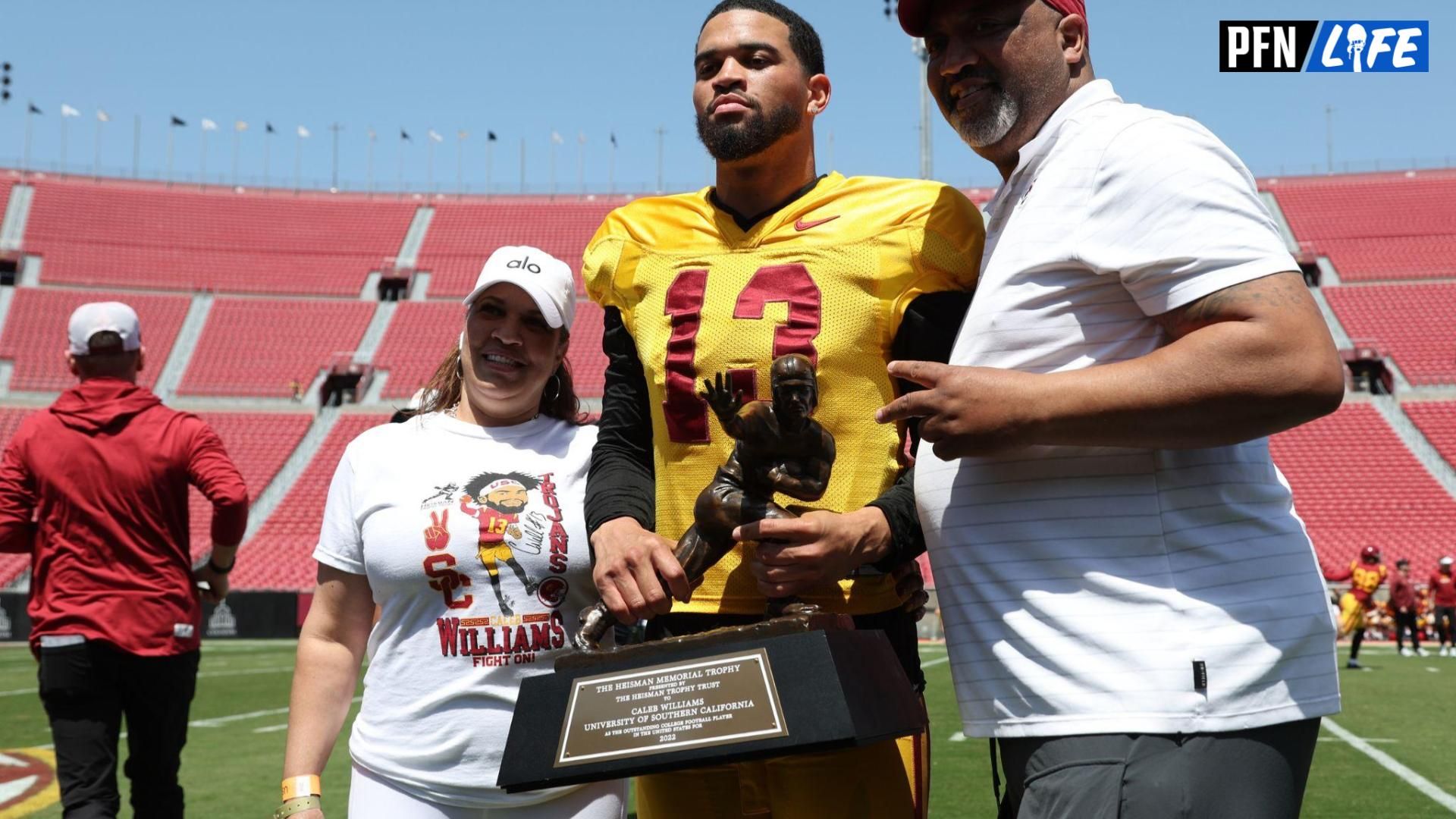 USC Trojans quarterback Caleb Williams (13) holds the Heisman Trophy with his parents during the Spring Game at Los Angeles Memorial Coliseum.