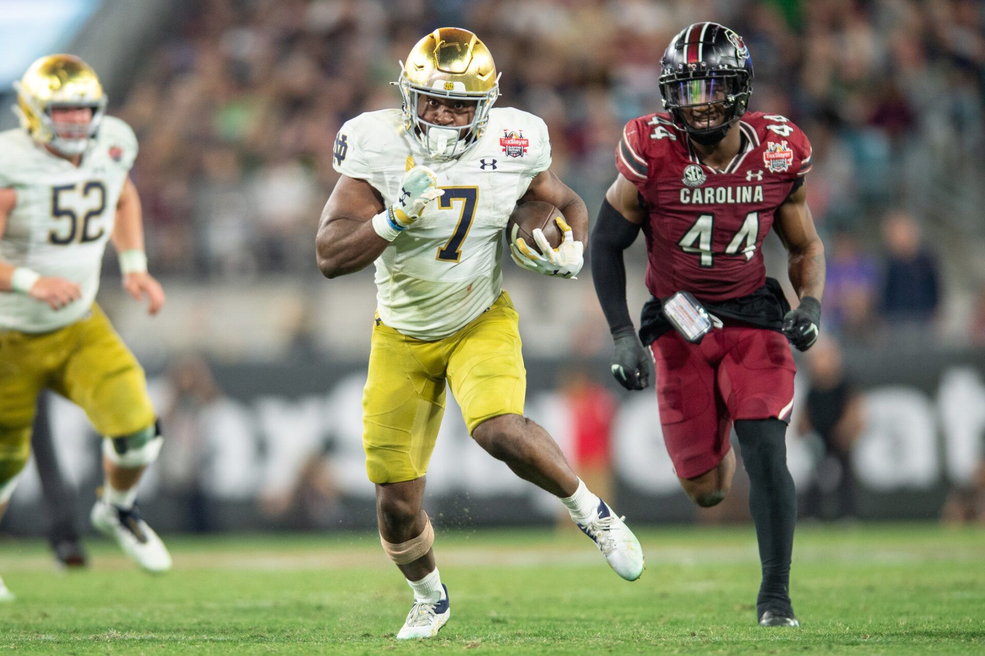 Notre Dame Fighting Irish running back Audric Estime (7) runs the ball past South Carolina Gamecocks linebacker Sherrod Greene (44) in the fourth quarter in the 2022 Gator Bowl at TIAA Bank Field. Mandatory Credit: Jeremy Reper-USA TODAY Sports