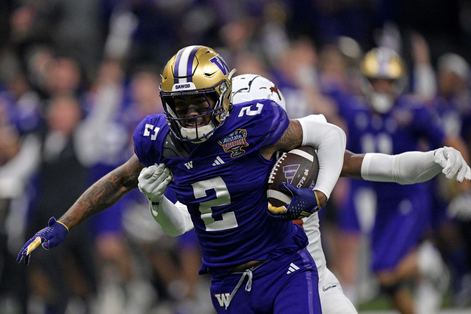 Washington Huskies wide receiver Ja'Lynn Polk (2) runs the ball after a catch against Texas Longhorns defensive back Terrance Brooks (8) during the first quarter in the 2024 Sugar Bowl college football playoff semifinal game at Caesars Superdome. Mandatory Credit: Matthew Hinton-USA TODAY Sports