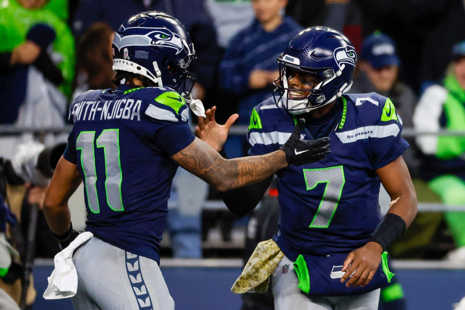 Seattle Seahawks quarterback Geno Smith (7) celebrates with wide receiver Jaxon Smith-Njigba (11) after throwing a touchdown pass against the Washington Commanders during the fourth quarter at Lumen Field.