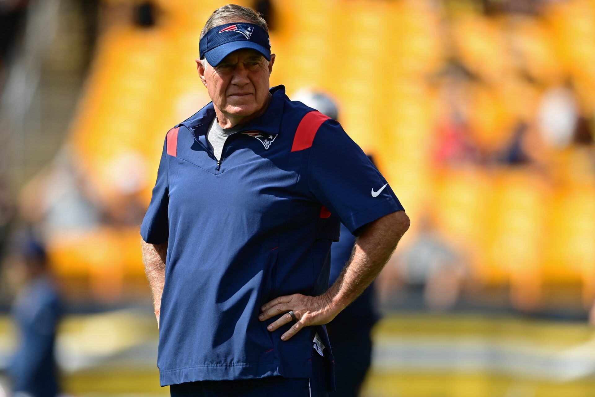 New England Patriots head coach Bill Belichick stands on the field before the game against the Pittsburgh Steelers at Acrisure Stadium.